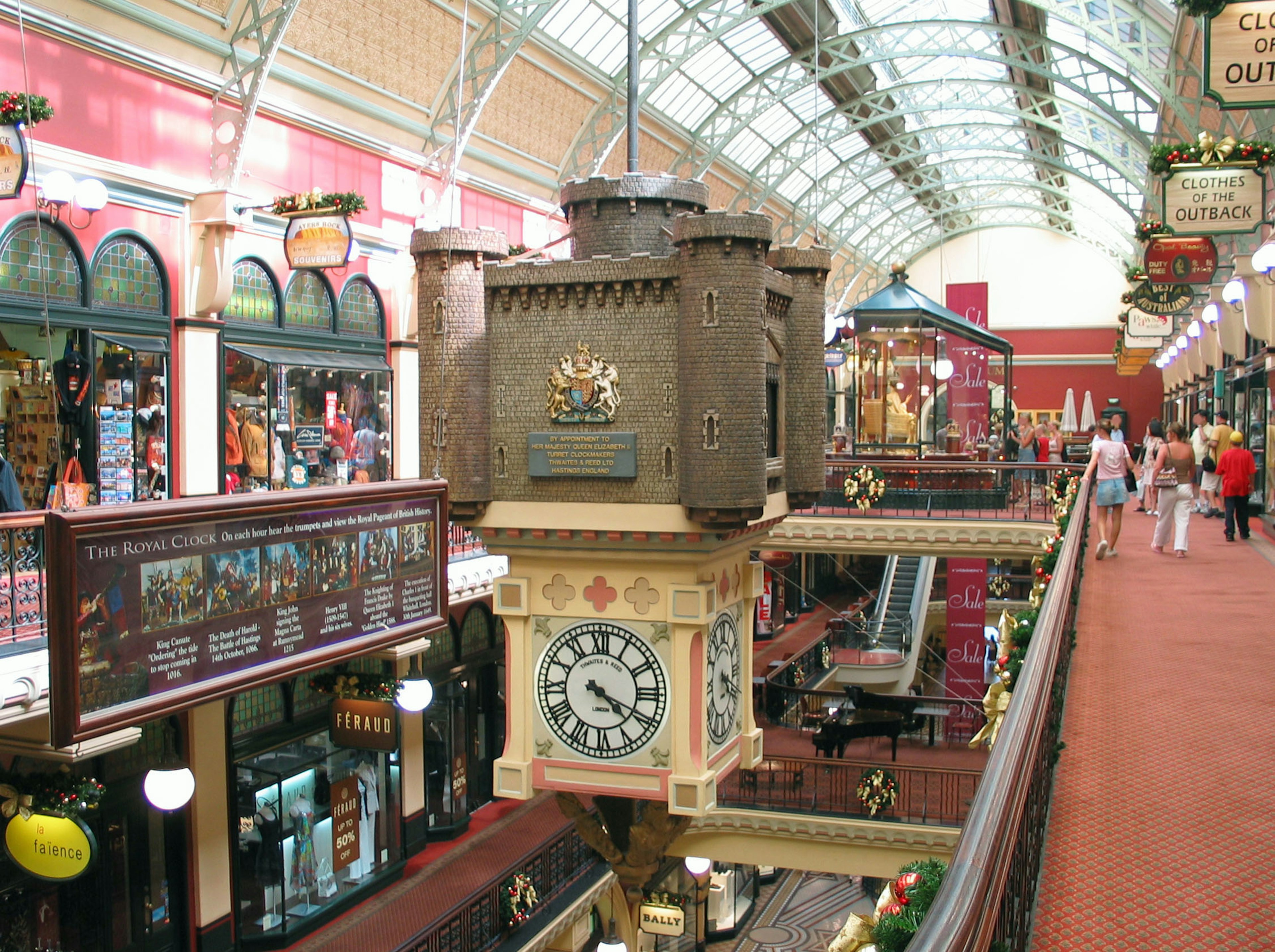 Grande horloge dans une arcade animée avec des boutiques colorées