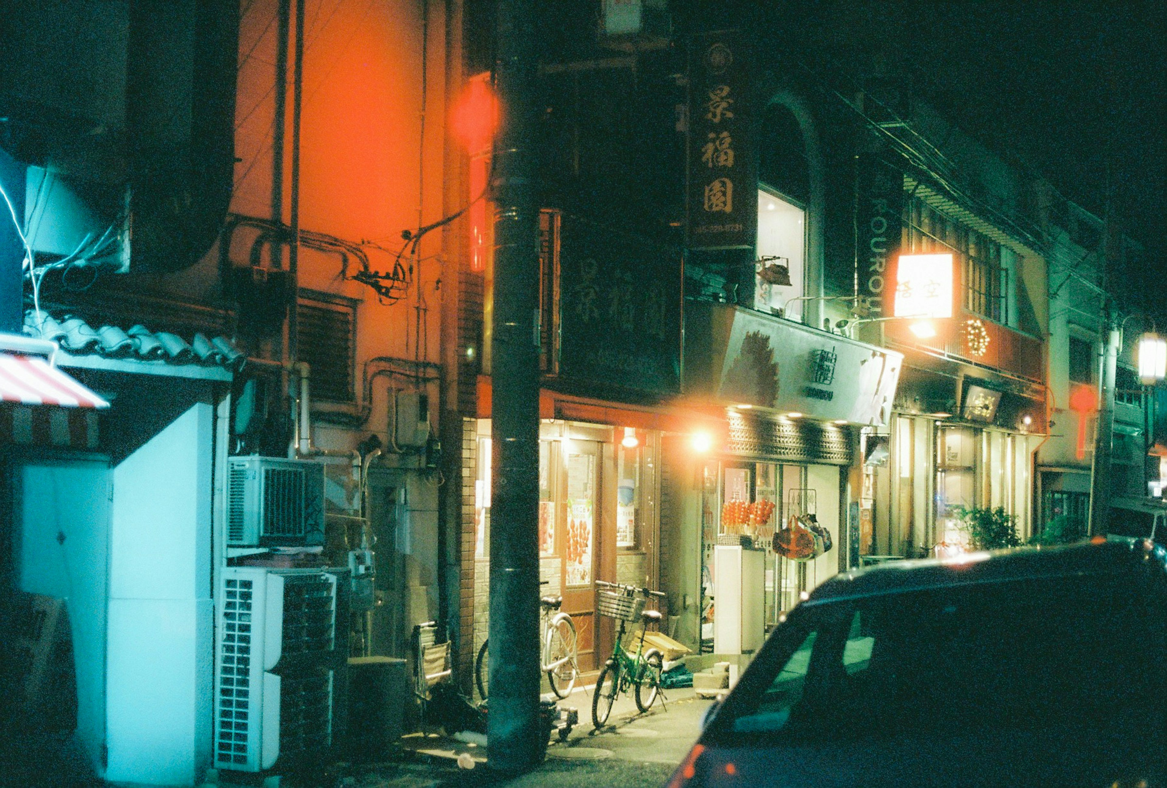 Night street scene with colorful neon lights old buildings and a bicycle