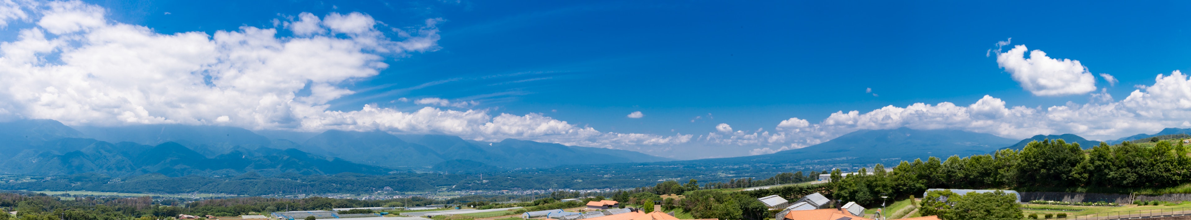 Vue panoramique des montagnes sous un ciel bleu avec des nuages blancs