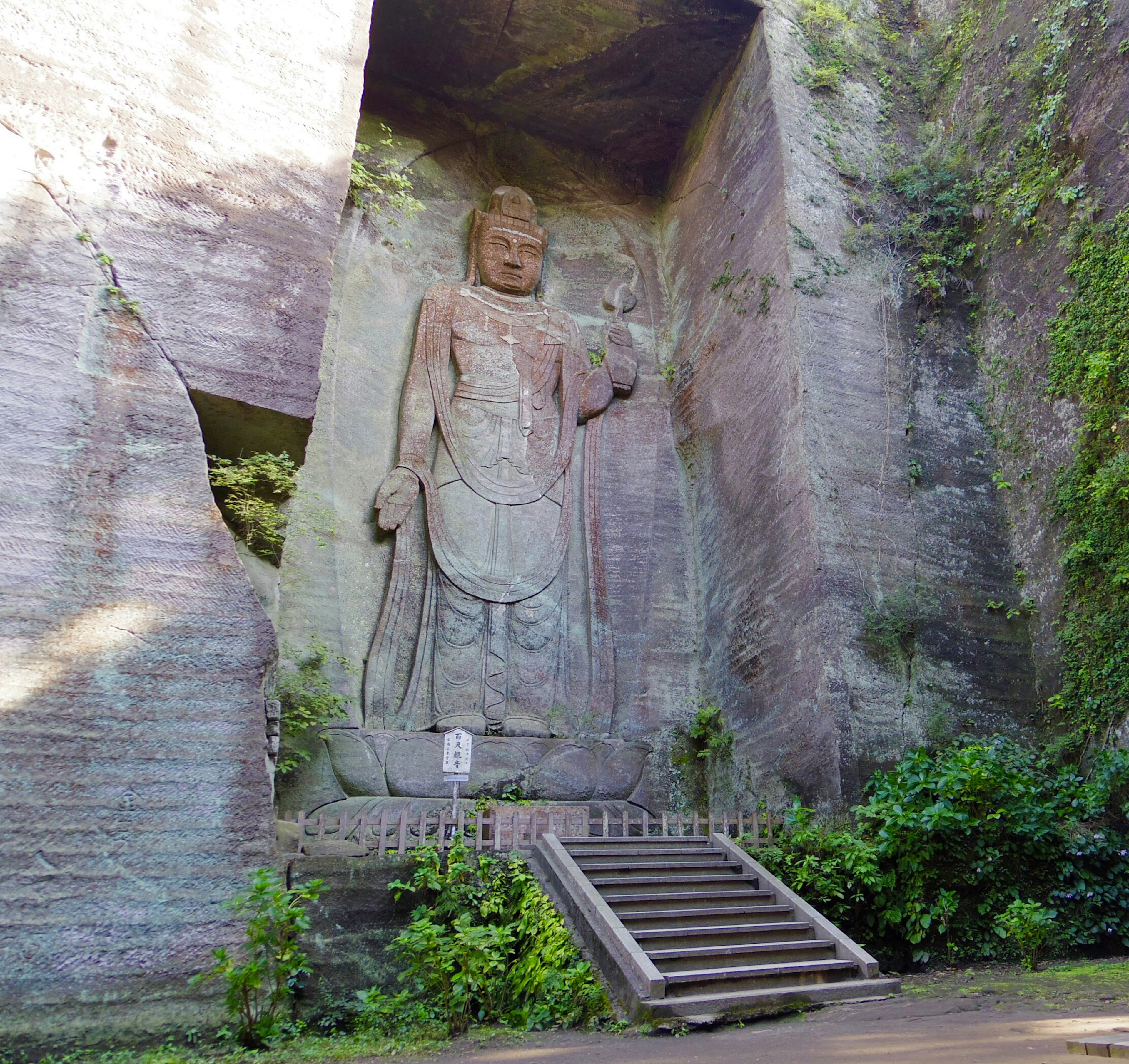 Patung Buddha besar yang diukir dari batu dalam lingkungan gua alami