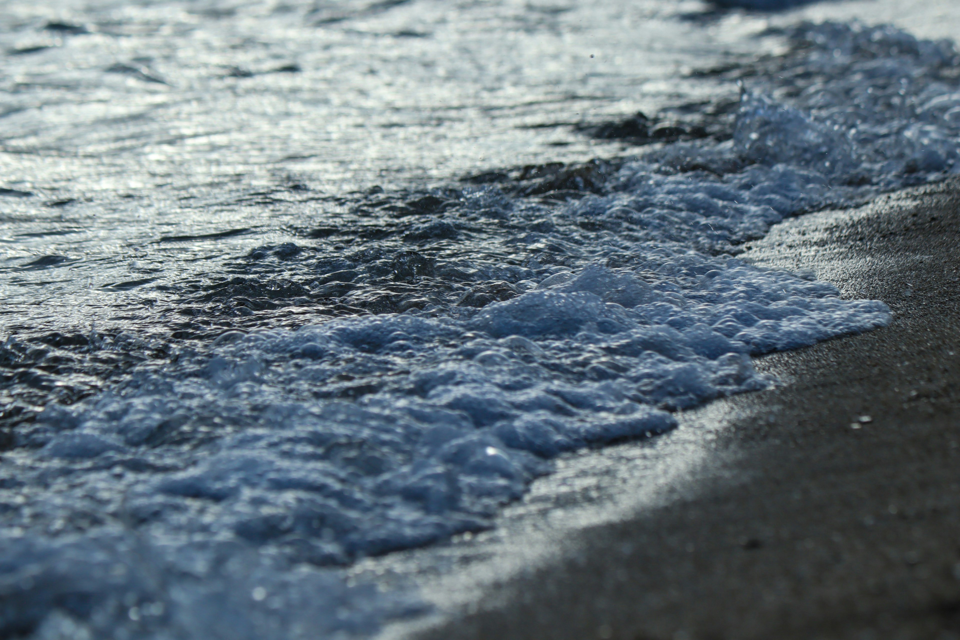 Wellen des Ozeans, die am Sandstrand brechen