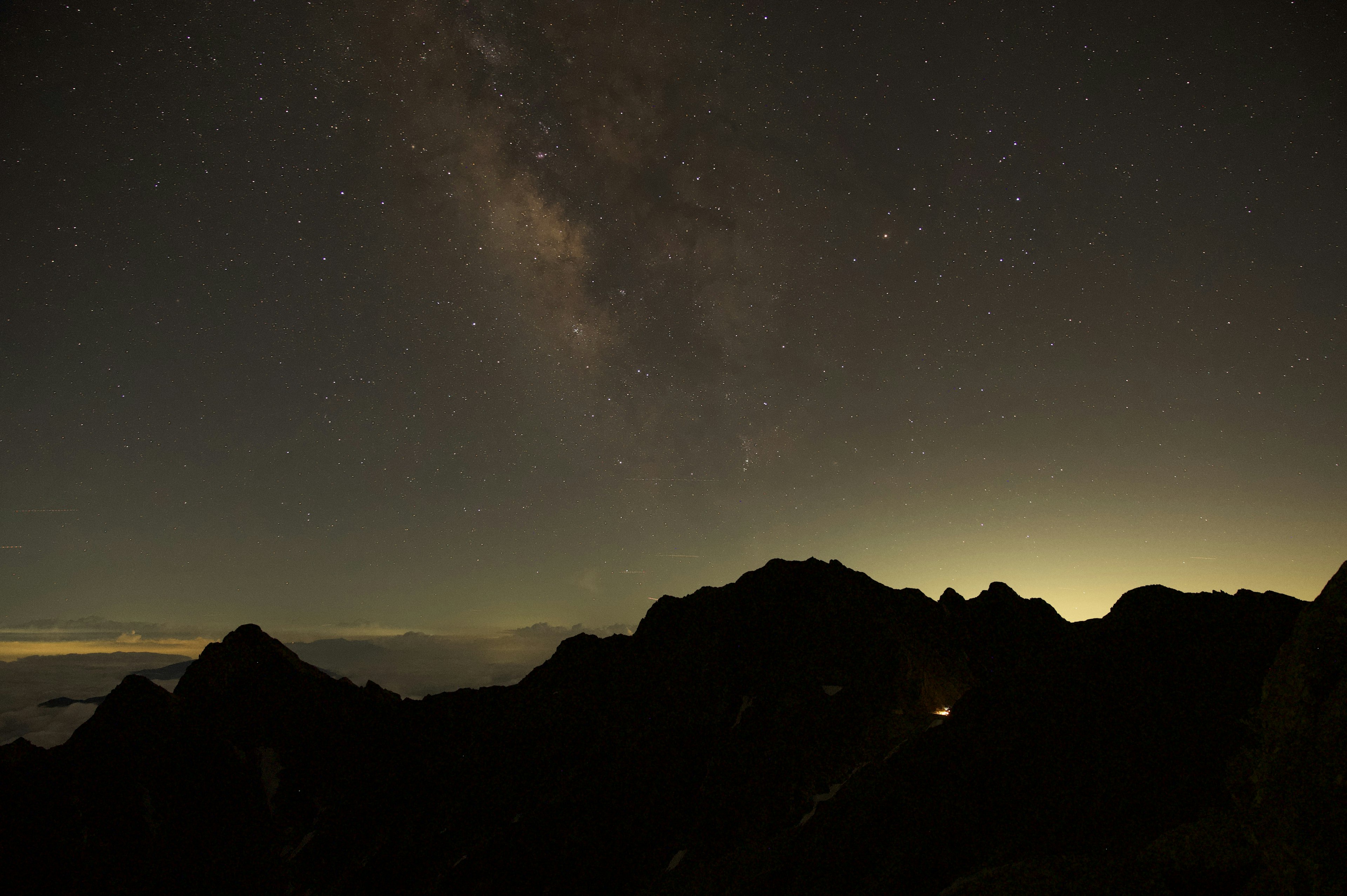 Night landscape featuring a starry sky and mountain silhouette