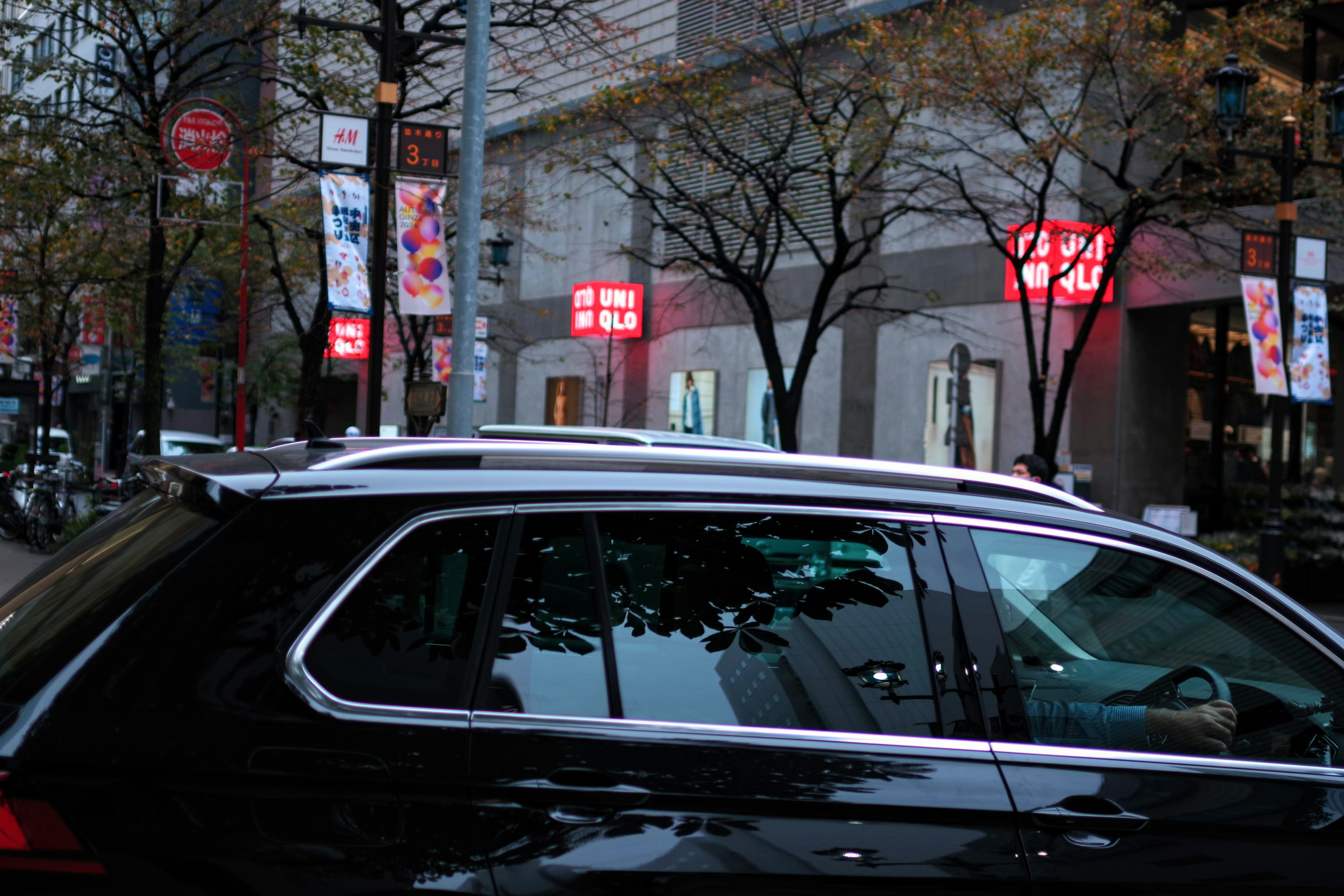 SUV noir garé dans une rue de la ville avec des panneaux rouges en arrière-plan