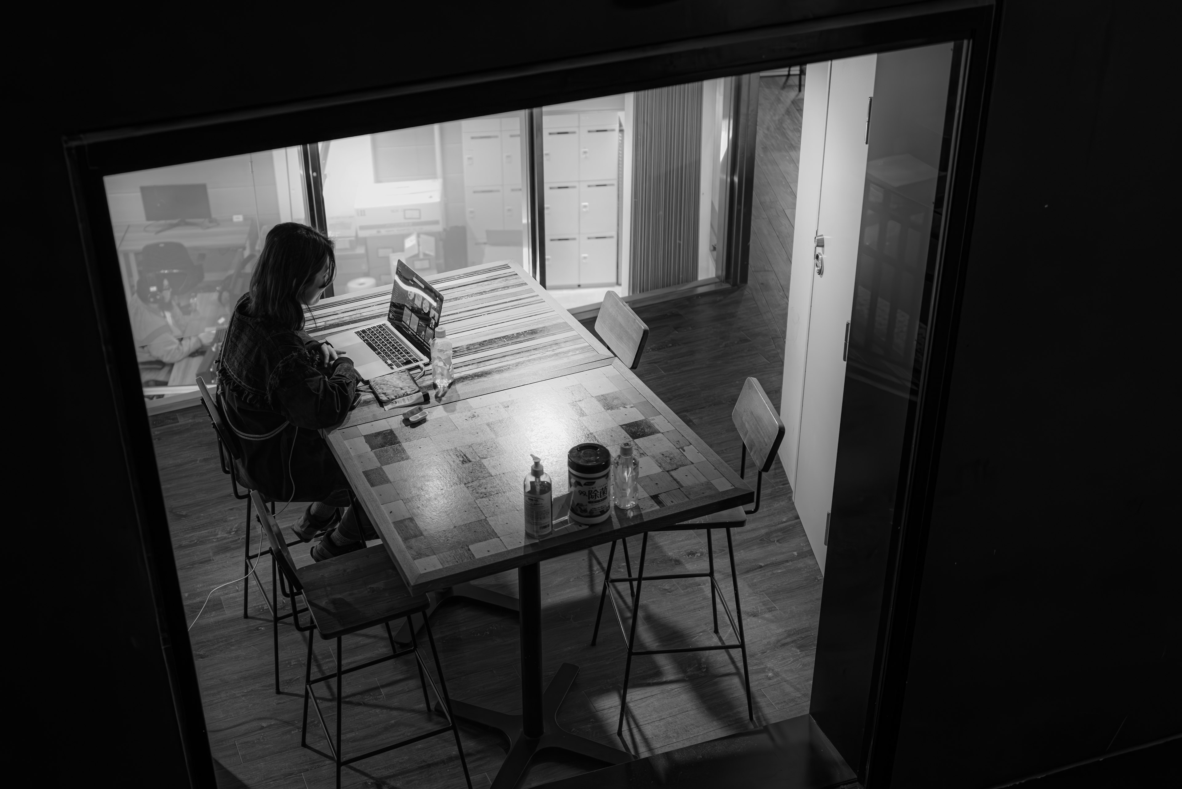 A woman working at a table in a monochrome room