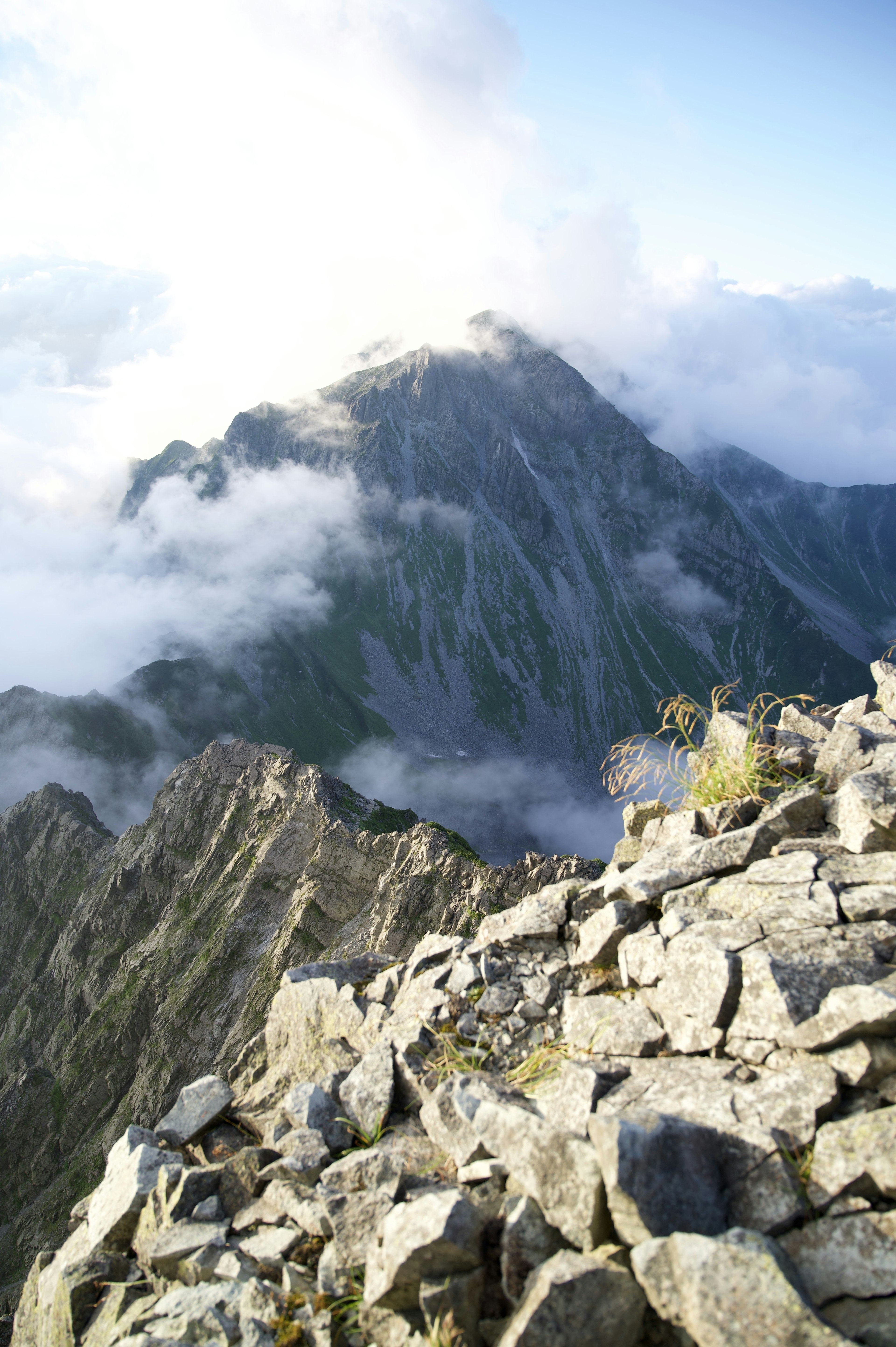 Vista panoramica da un picco montano con terreno roccioso e nuvole