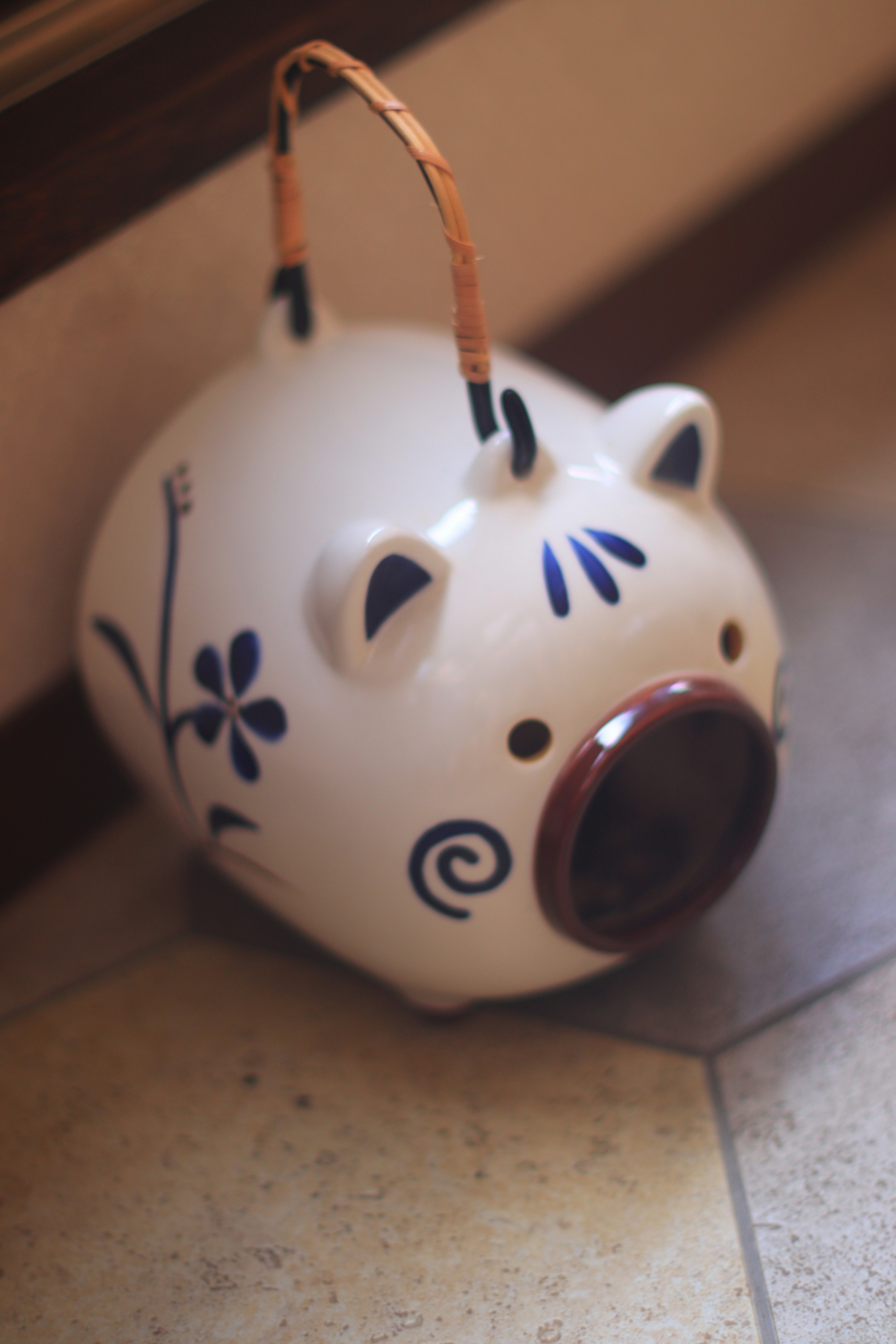 White piggy bank with blue floral patterns and brown snout