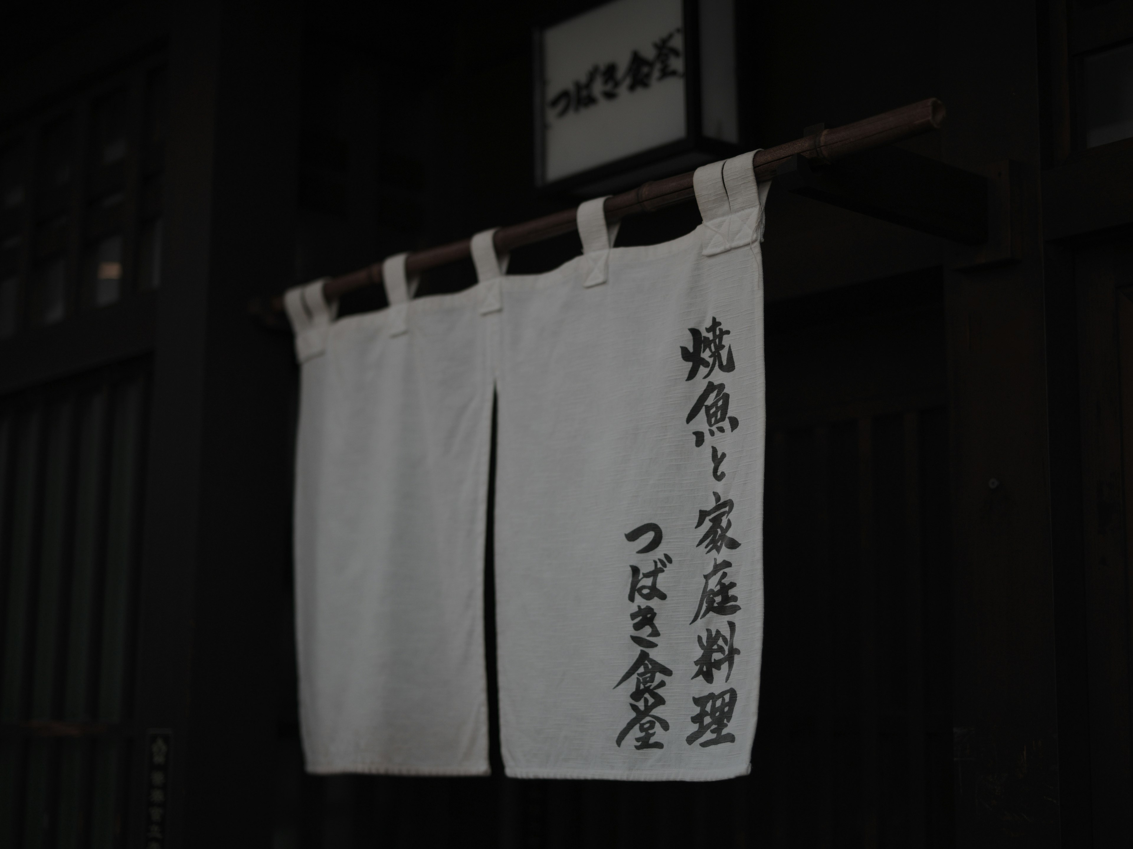 Traditional Japanese noren curtain with kanji characters at a restaurant entrance