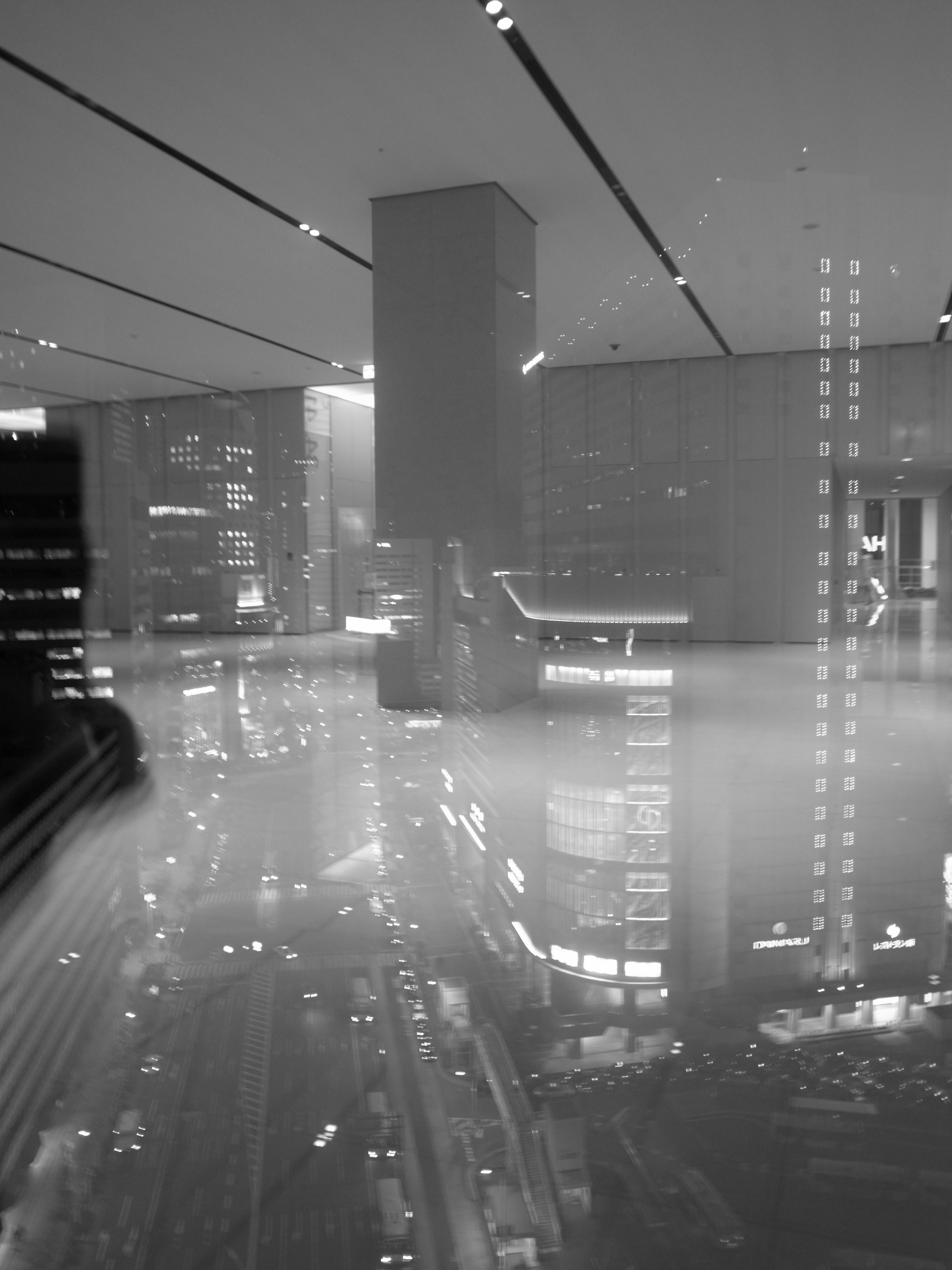 Black and white cityscape at night featuring buildings and traffic