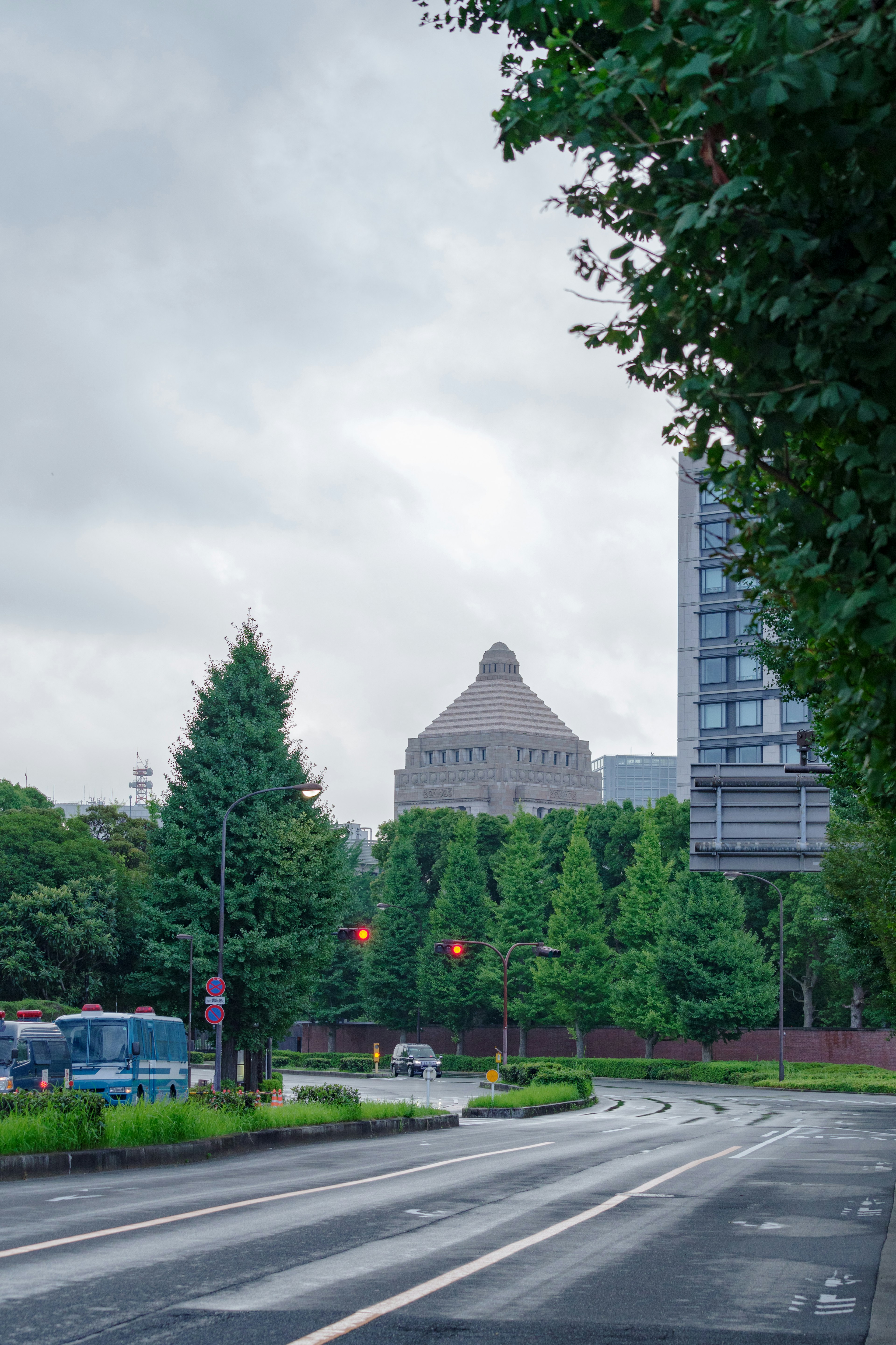 Straßenansicht mit grünen Bäumen und einem charakteristischen kuppelförmigen Gebäude im Hintergrund