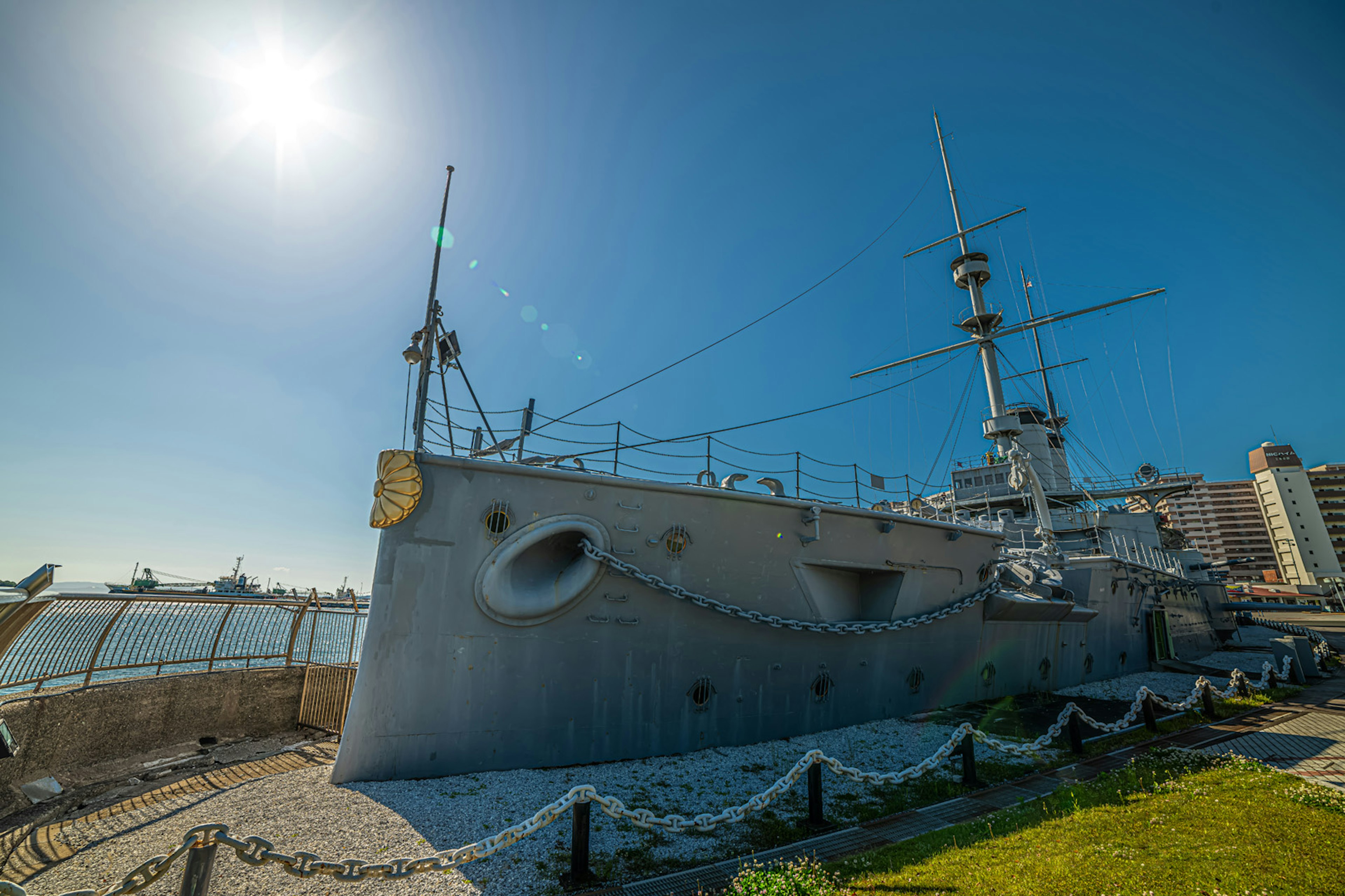 青空の下にある歴史的な軍艦とその周囲の風景