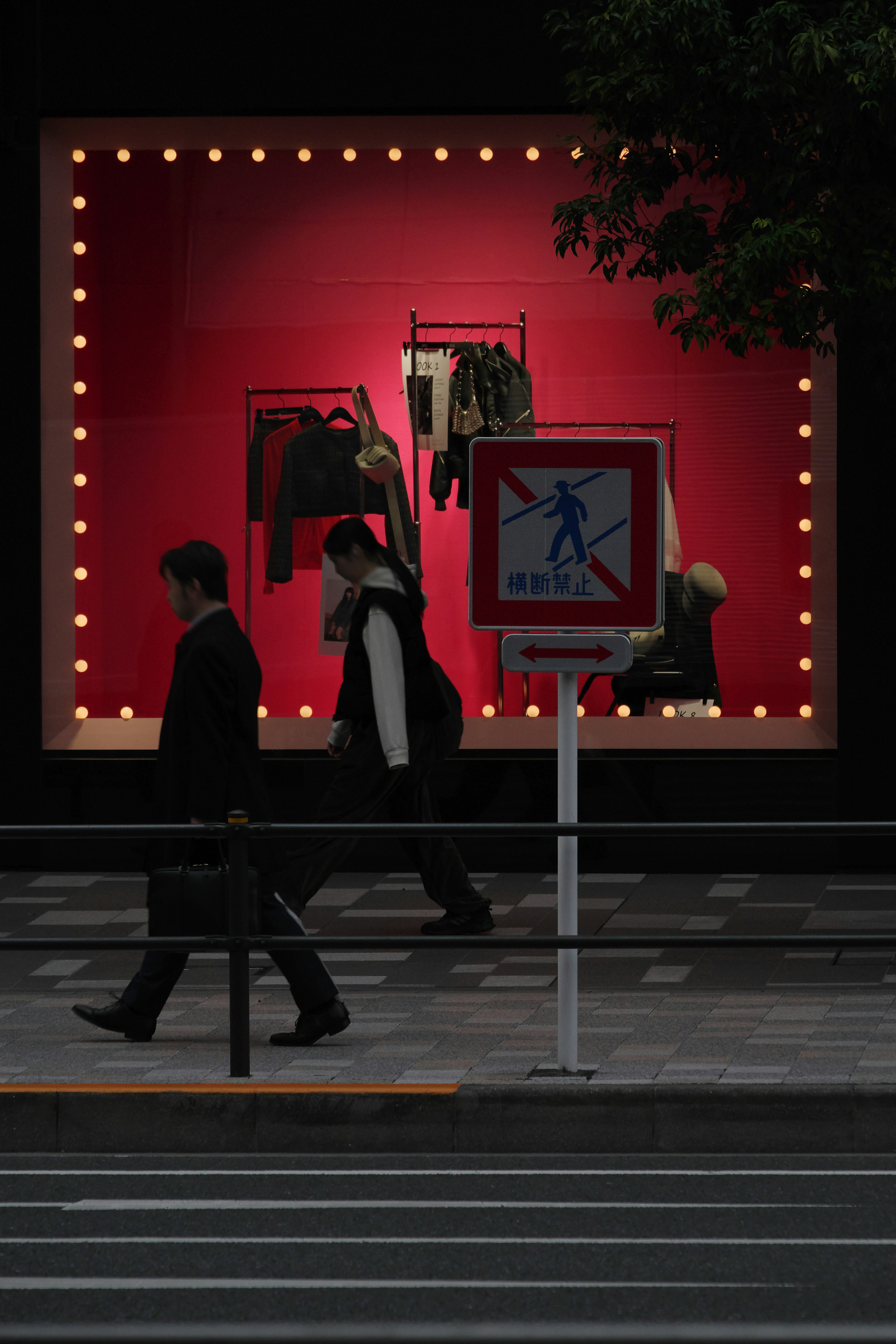 Urban scene featuring a red display window with hanging clothes