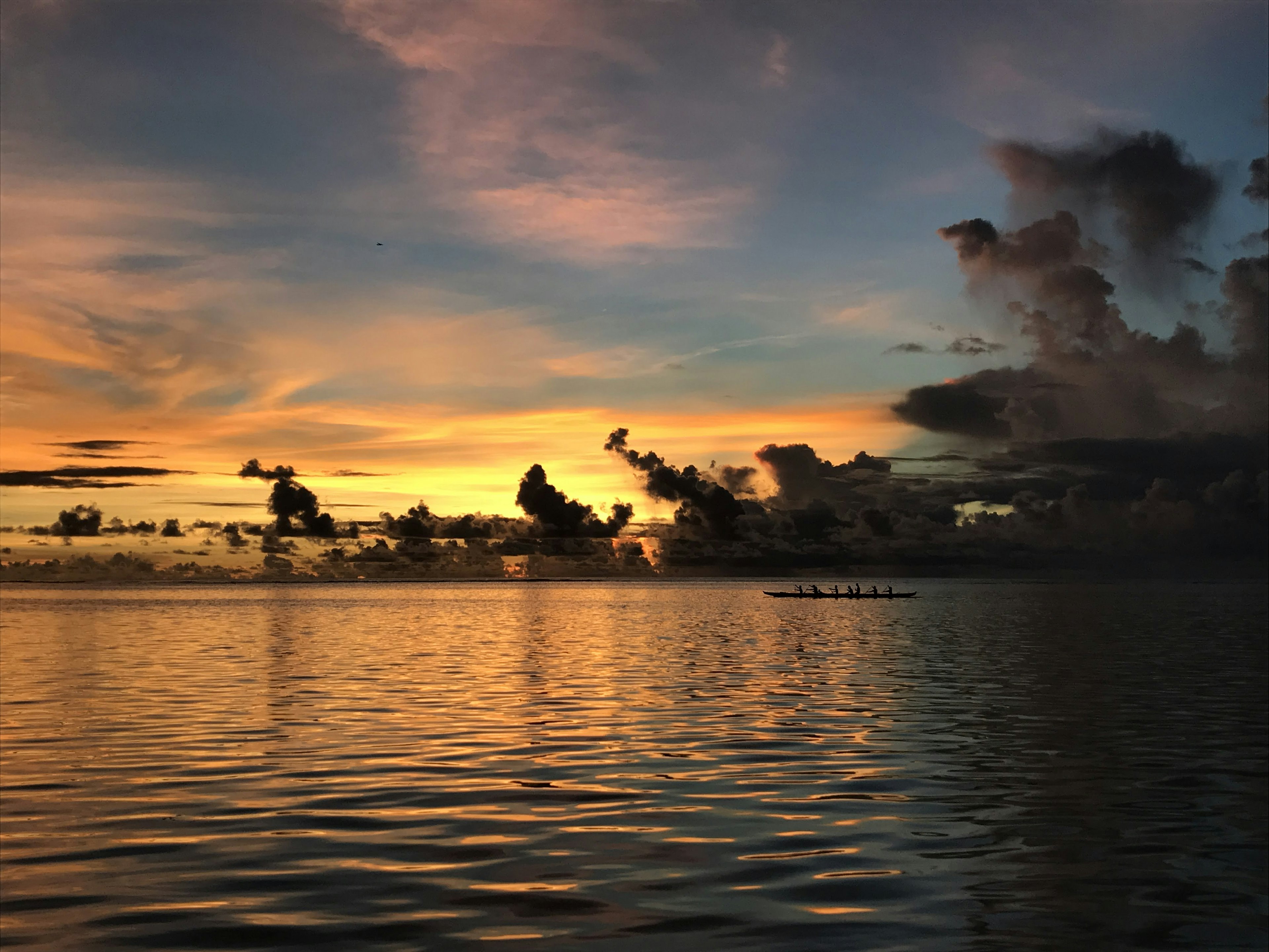 Hermoso atardecer sobre el océano con reflejos coloridos en el agua y siluetas de nubes