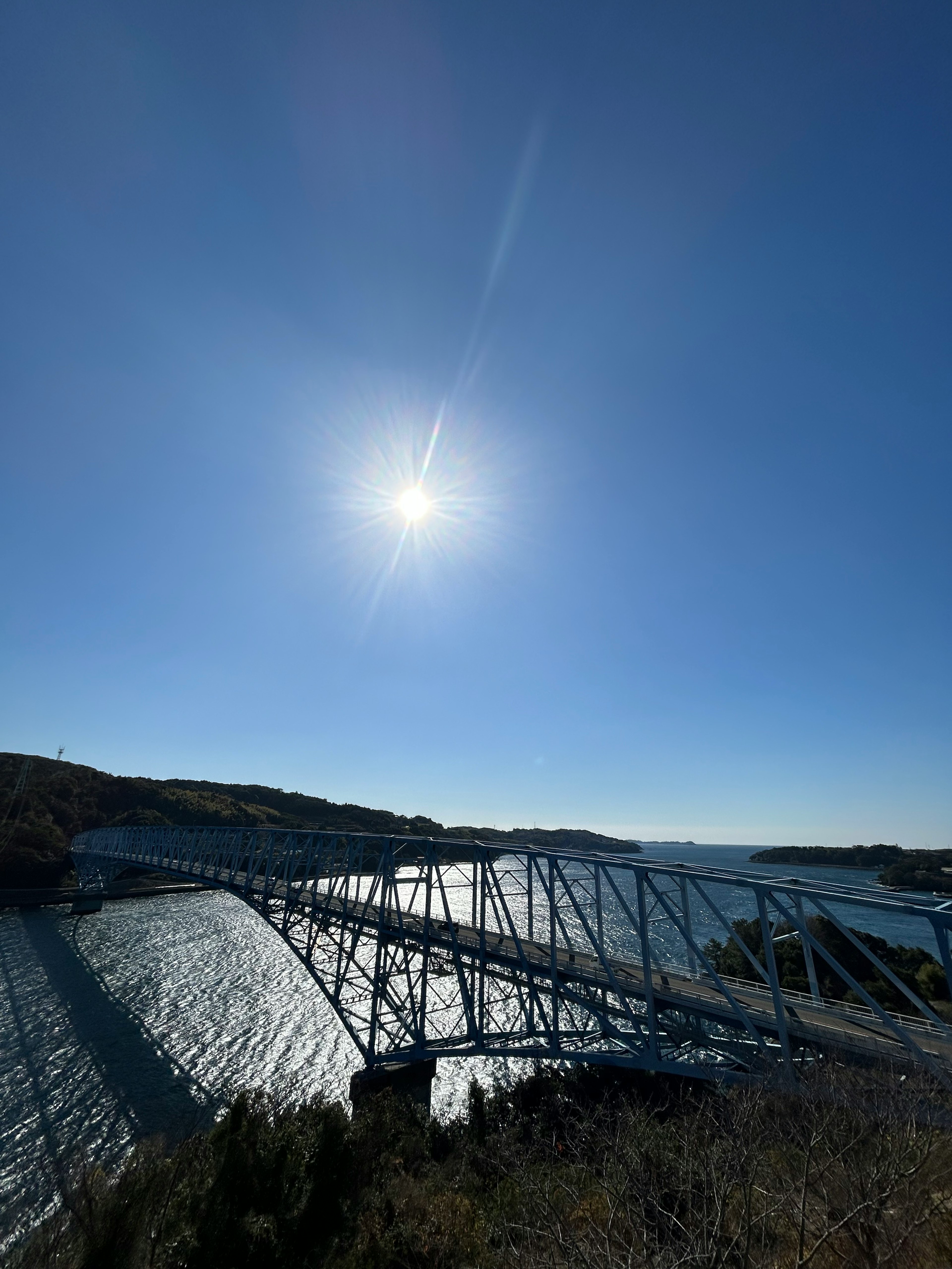 Malersicher Blick auf eine Brücke über Wasser unter klarem blauen Himmel