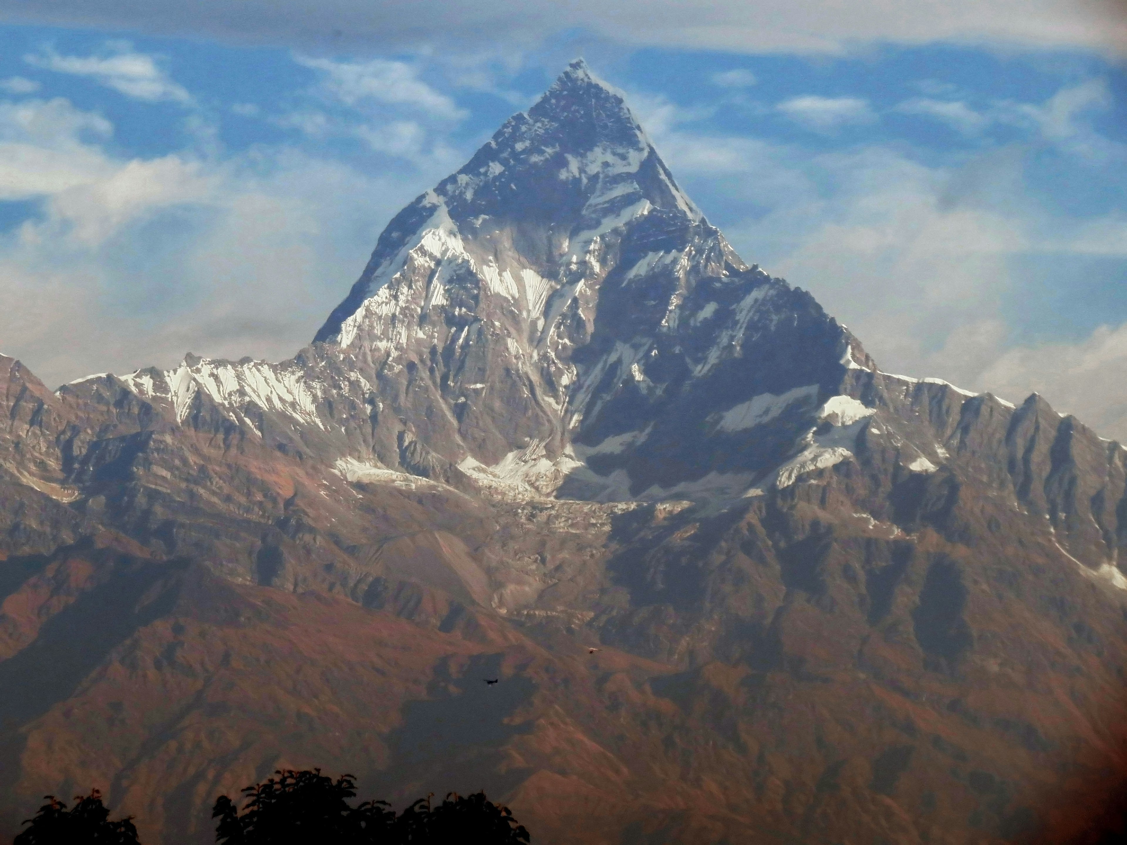 Snow-capped peak of a mountain towering under a blue sky