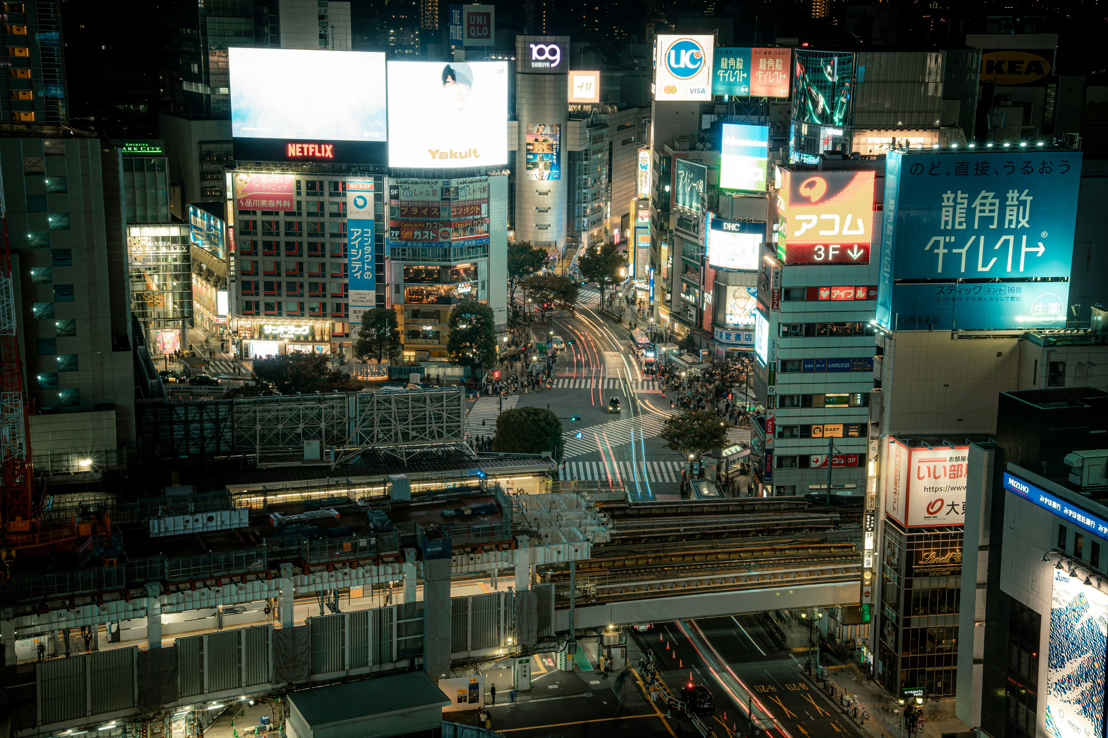 夜景の都市風景に輝く看板と交通の流れ