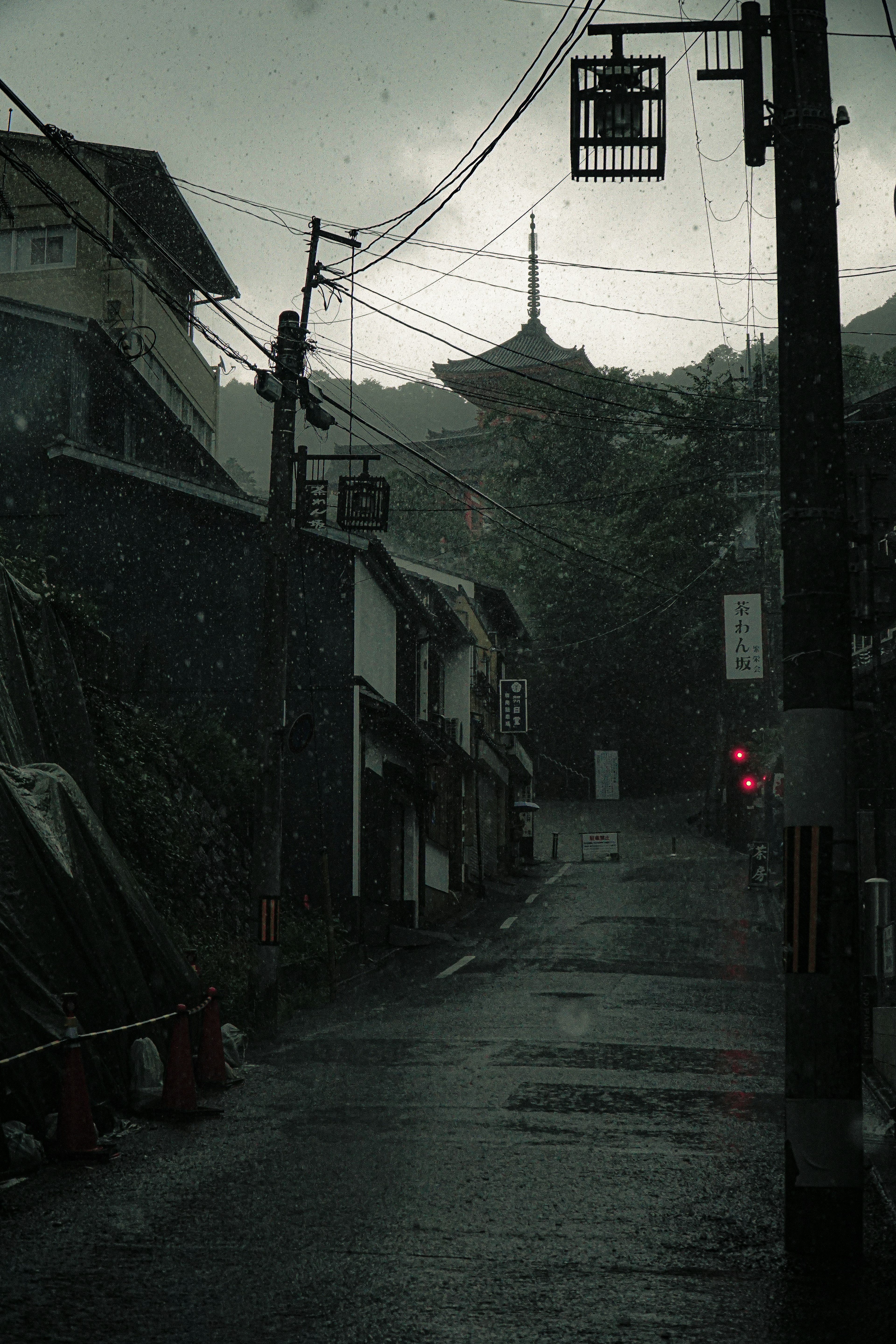 Quiet street in the rain with old buildings and a pagoda in the background