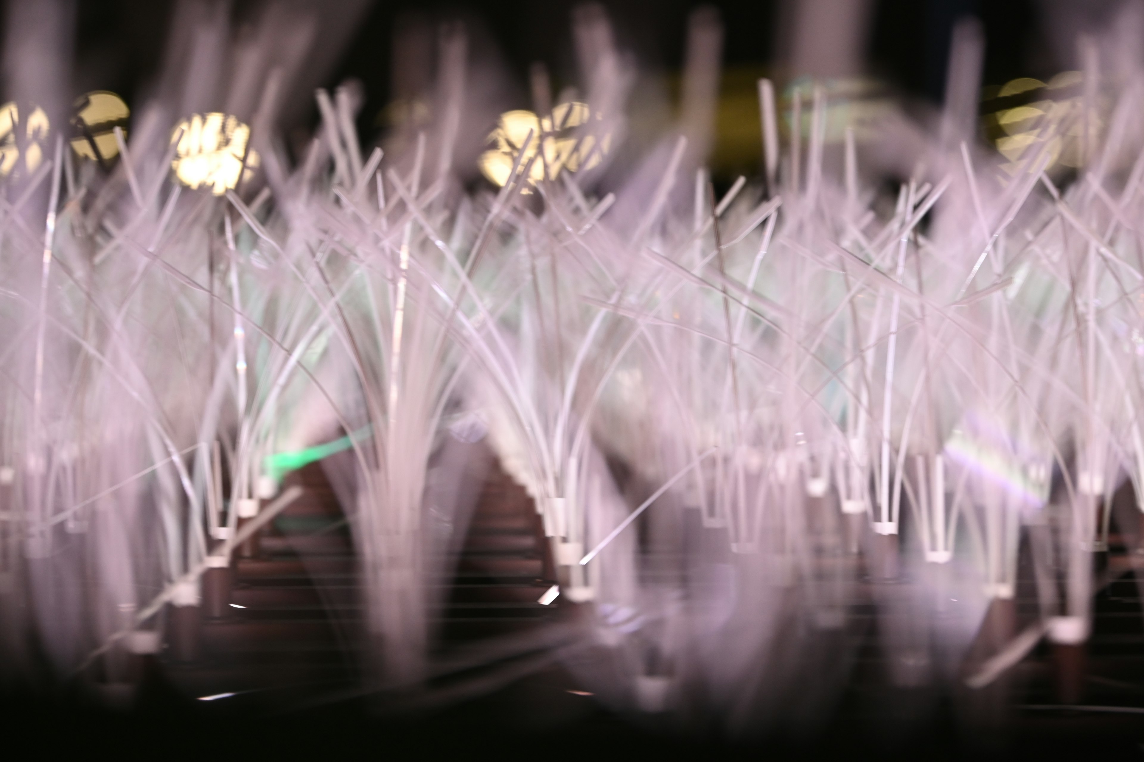 A landscape of glowing water fountain streams lined up