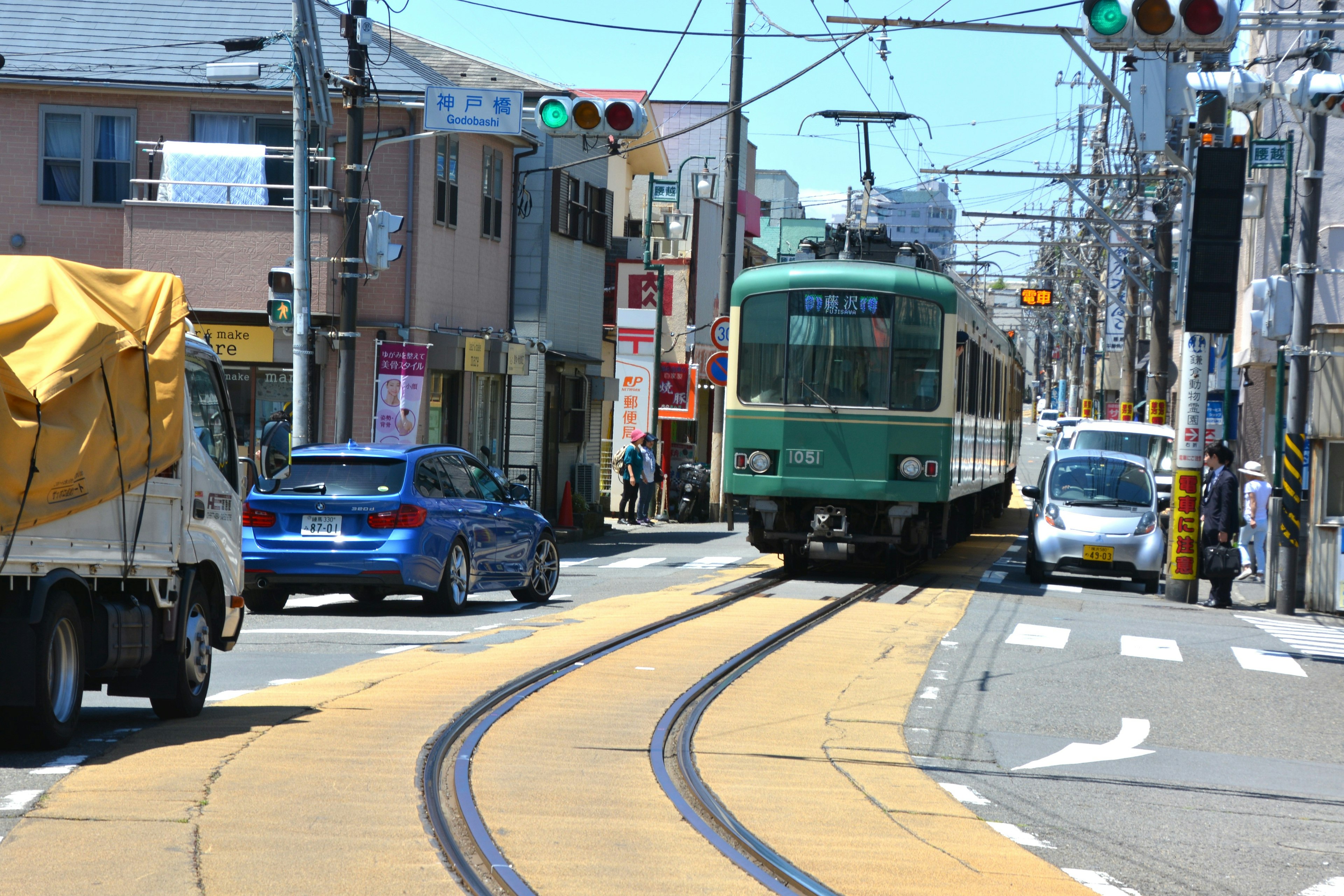 Green tram navigating through a city street