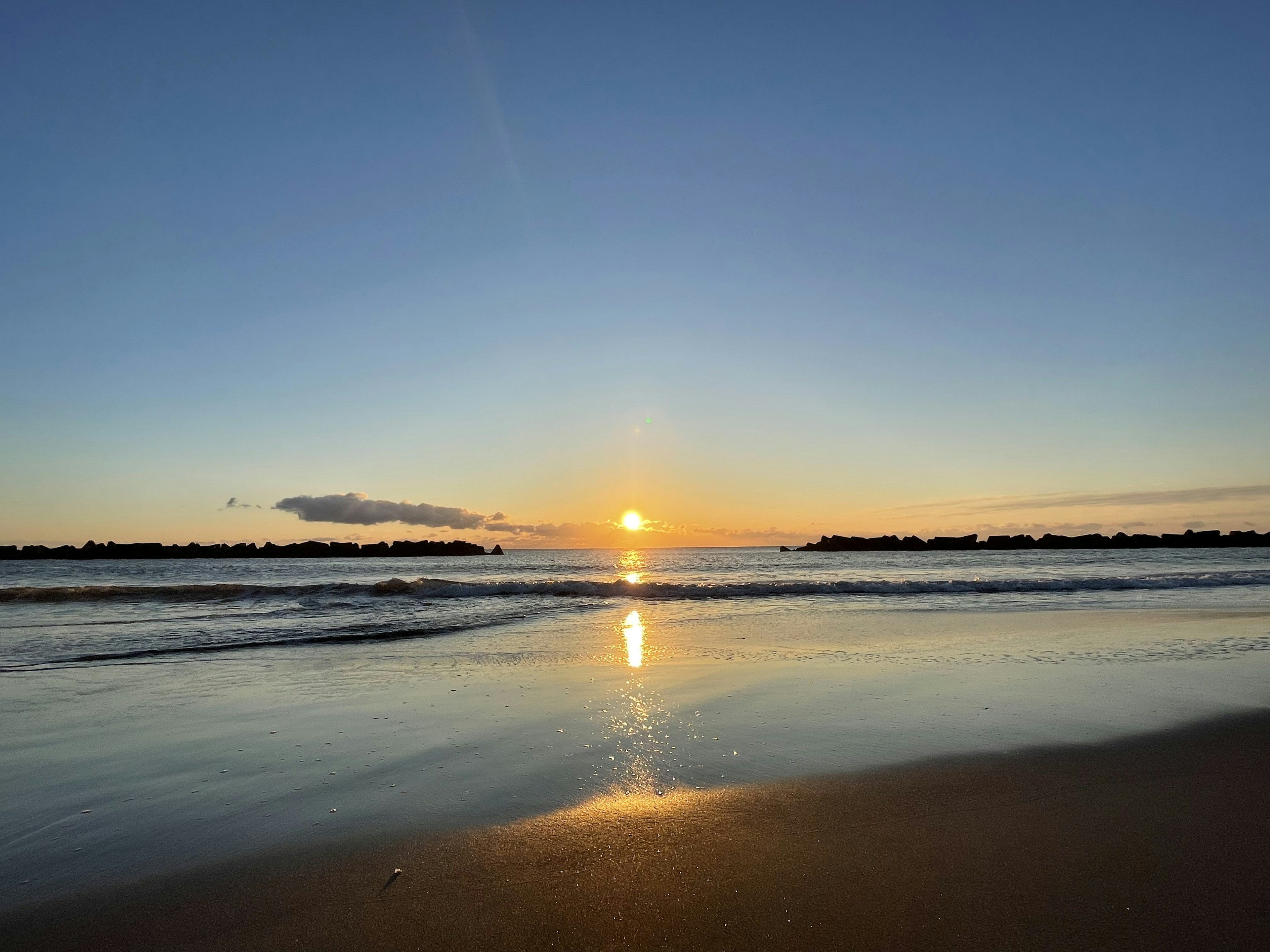 穏やかな海と美しい夕日が映るビーチの風景