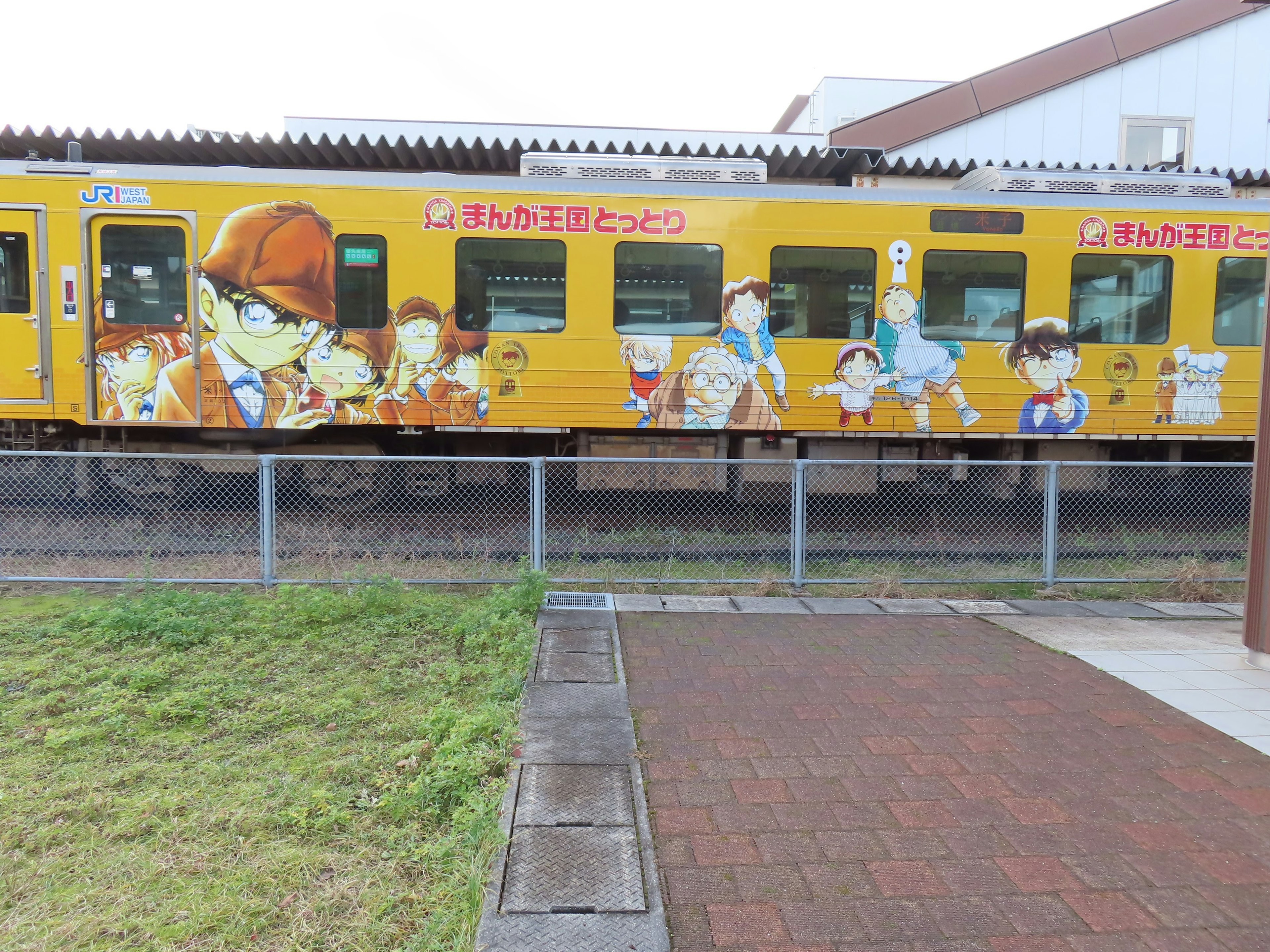 Yellow train adorned with anime character illustrations