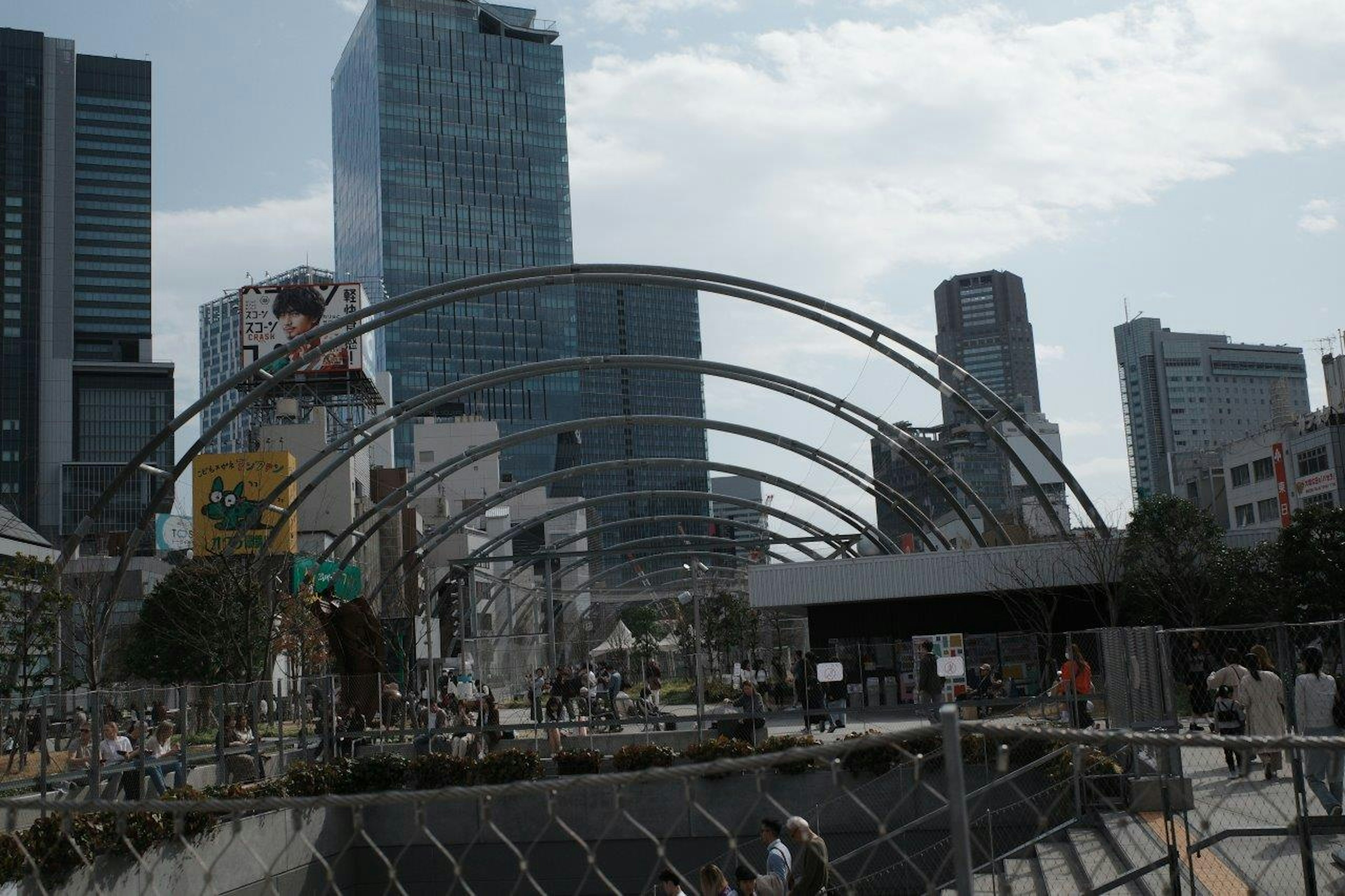 高層ビルが立ち並ぶ都市の風景と建設中のアーチ構造