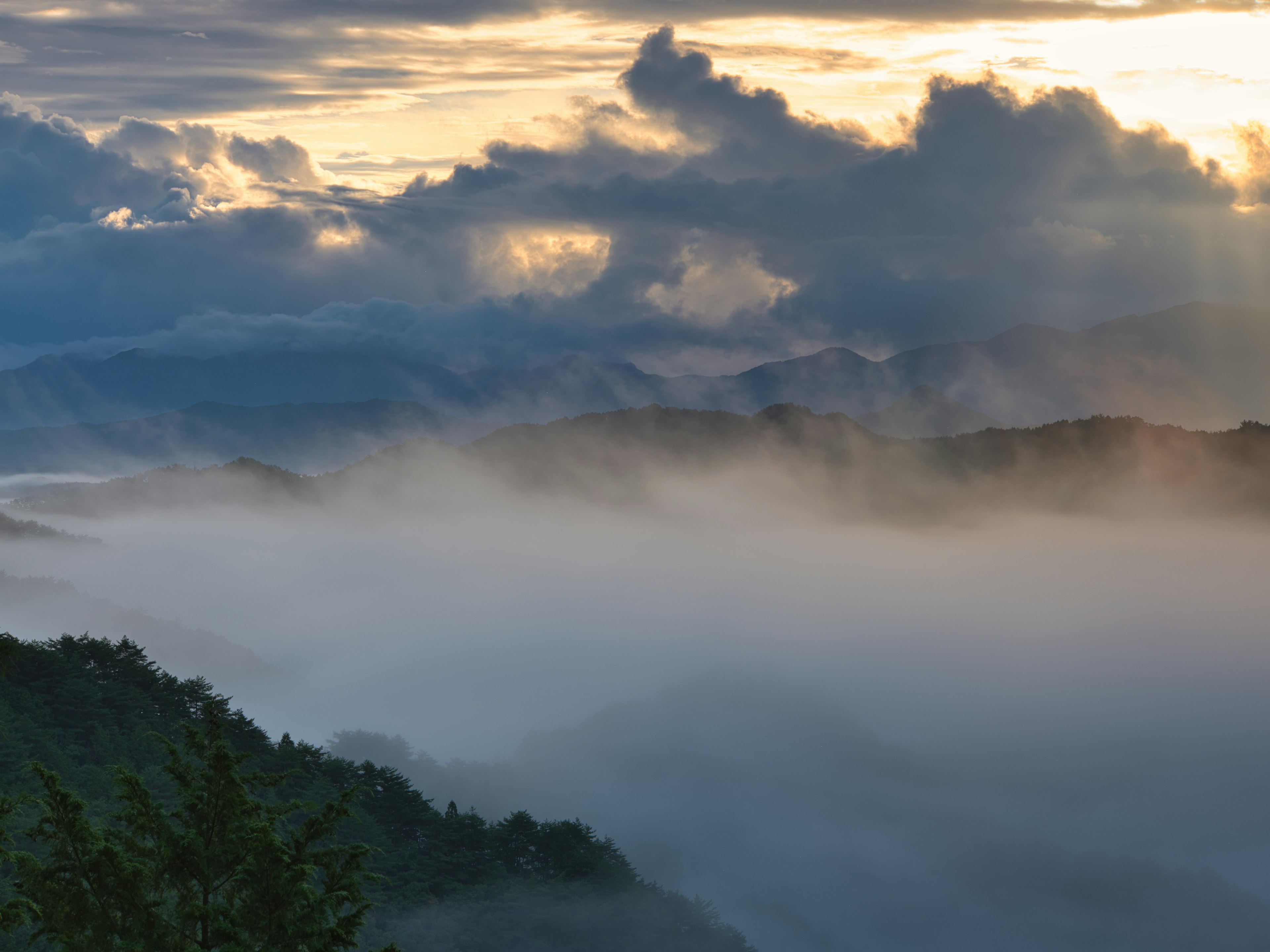 Nebelige Berge mit Wolken und dramatischem Himmel