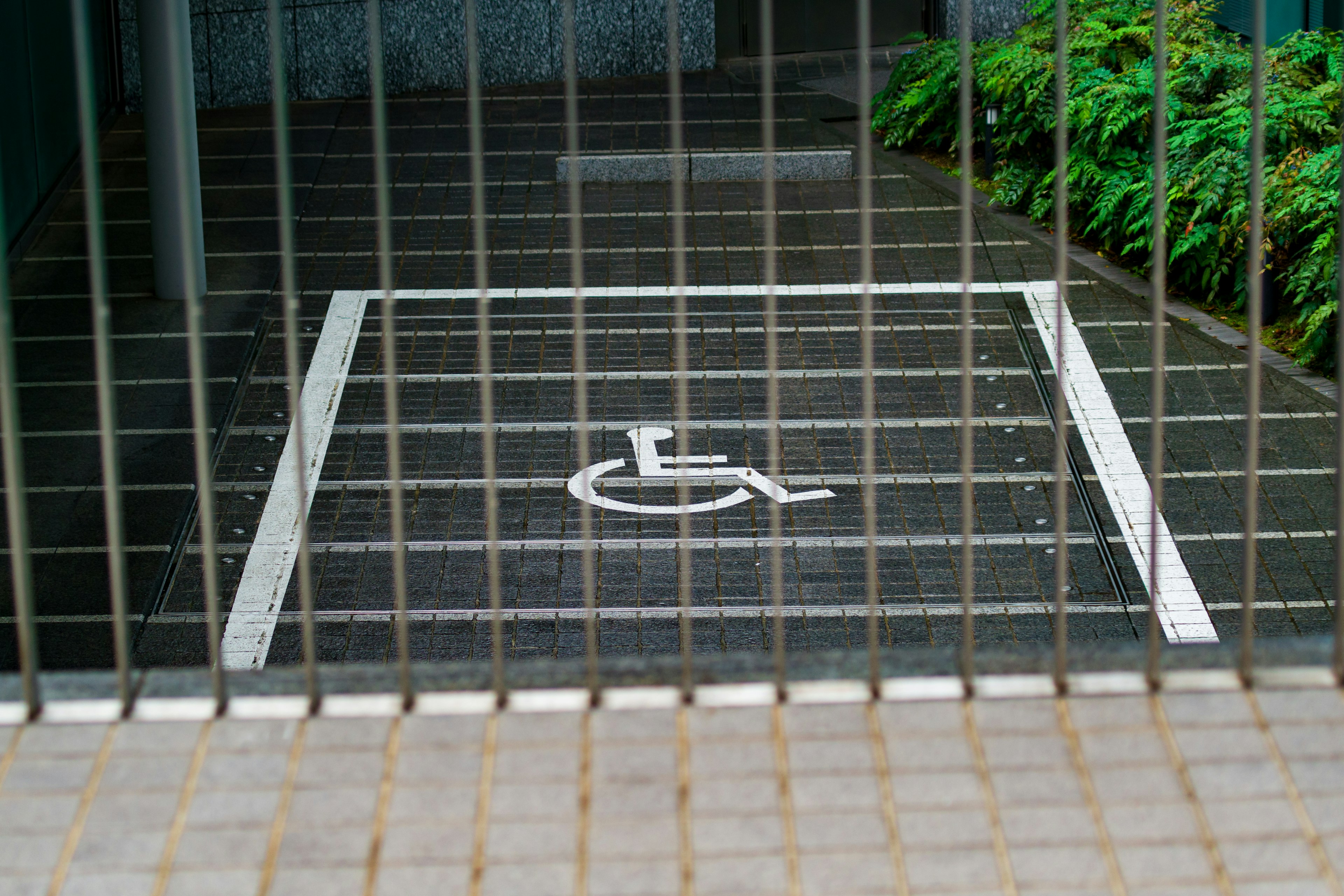 Imagen de un área pavimentada con un símbolo blanco que indica un espacio de estacionamiento para discapacitados