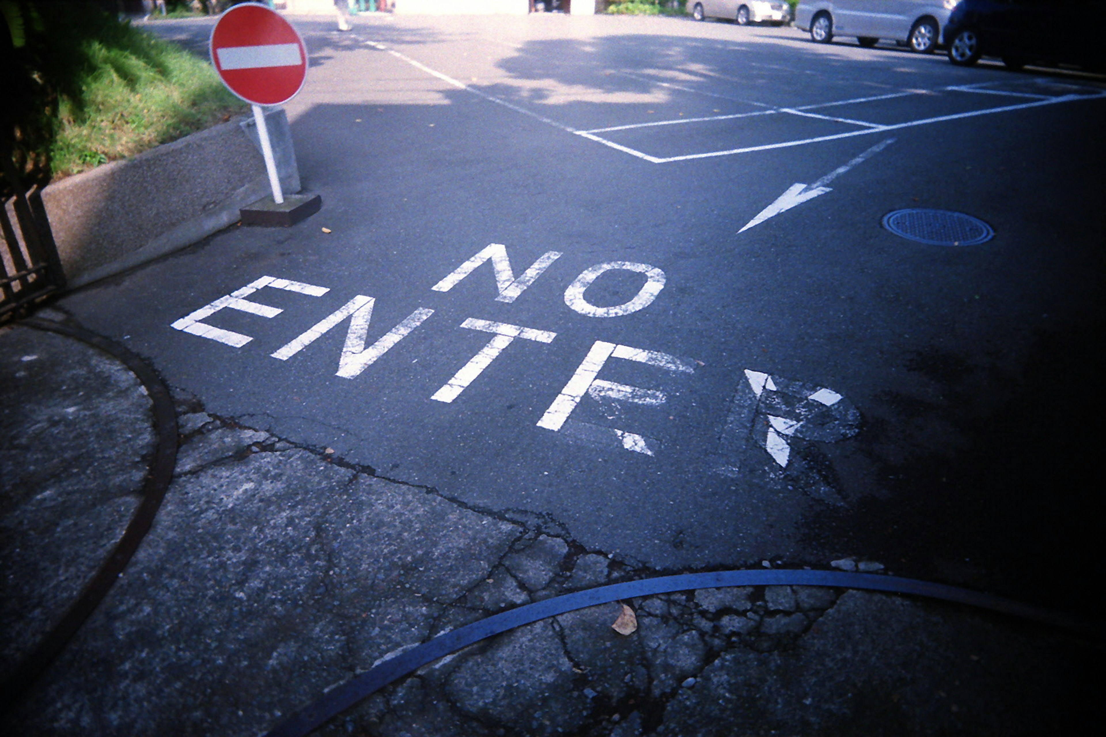 A parking area with a no entry sign and painted text