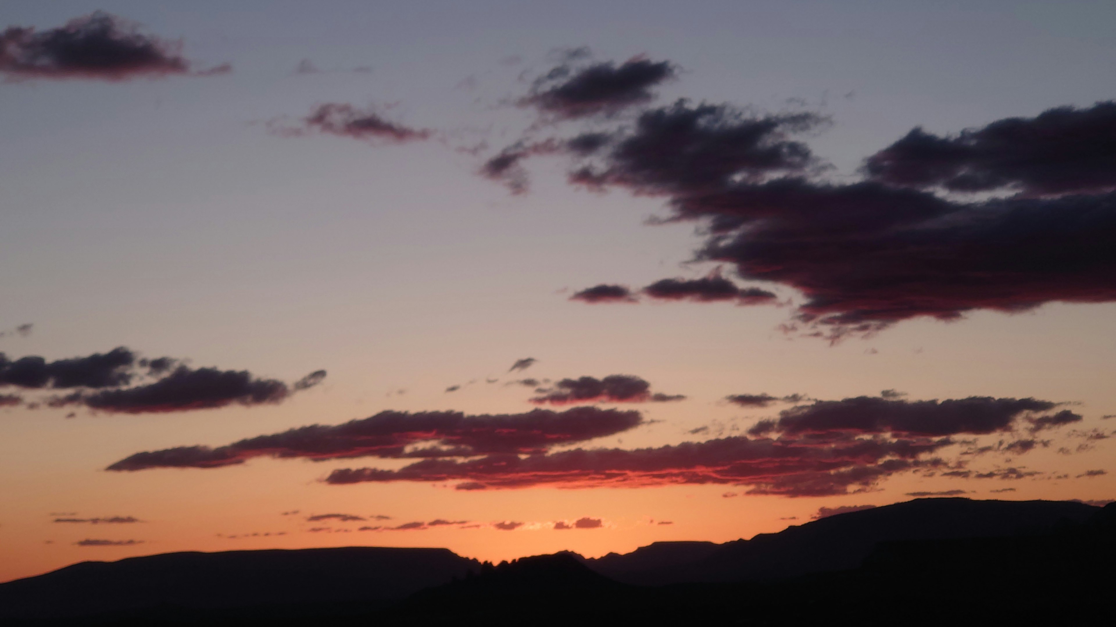 Cielo al tramonto con montagne in silhouette