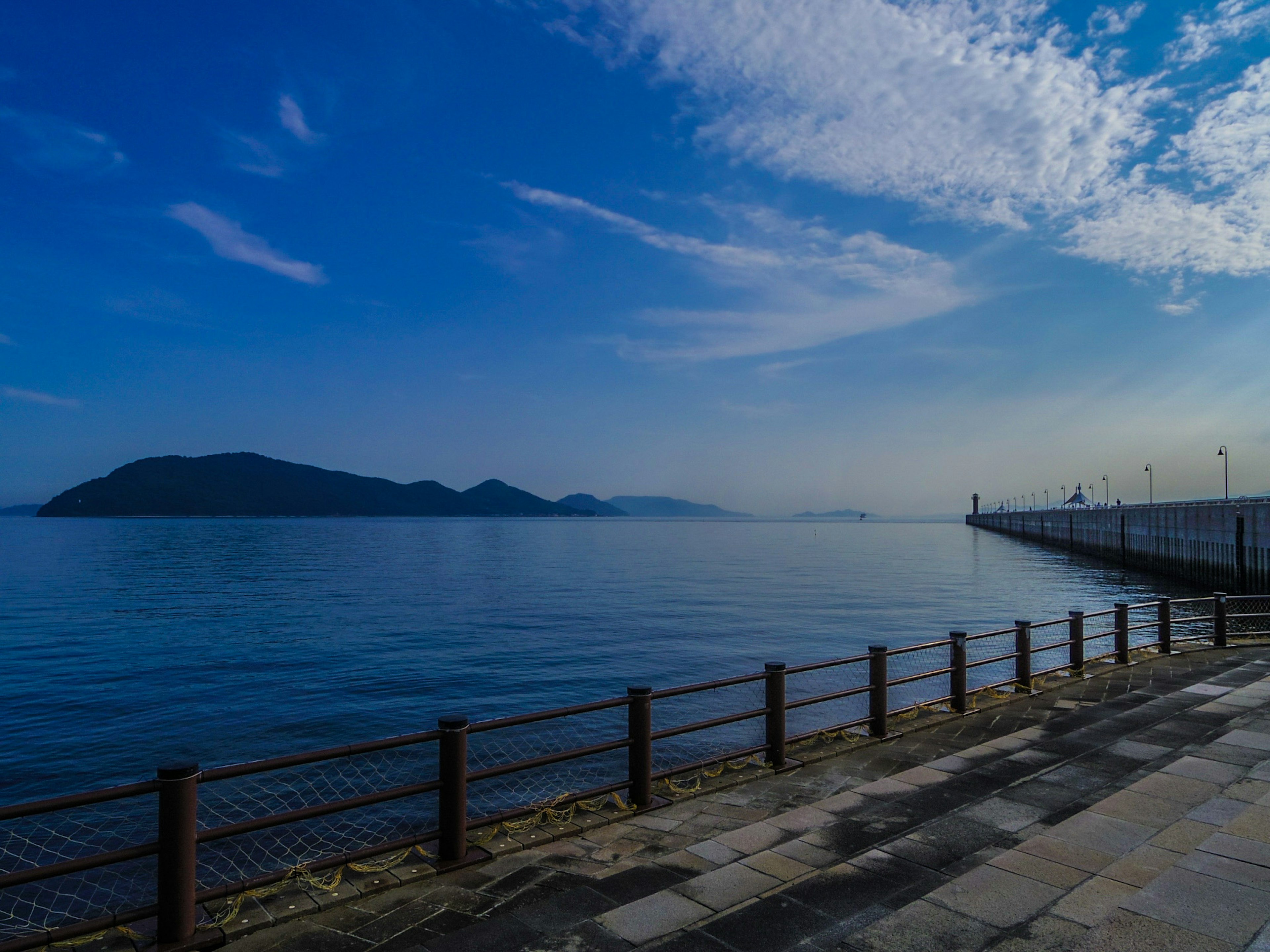 Pemandangan tepi laut yang indah dengan langit biru dan laut tenang