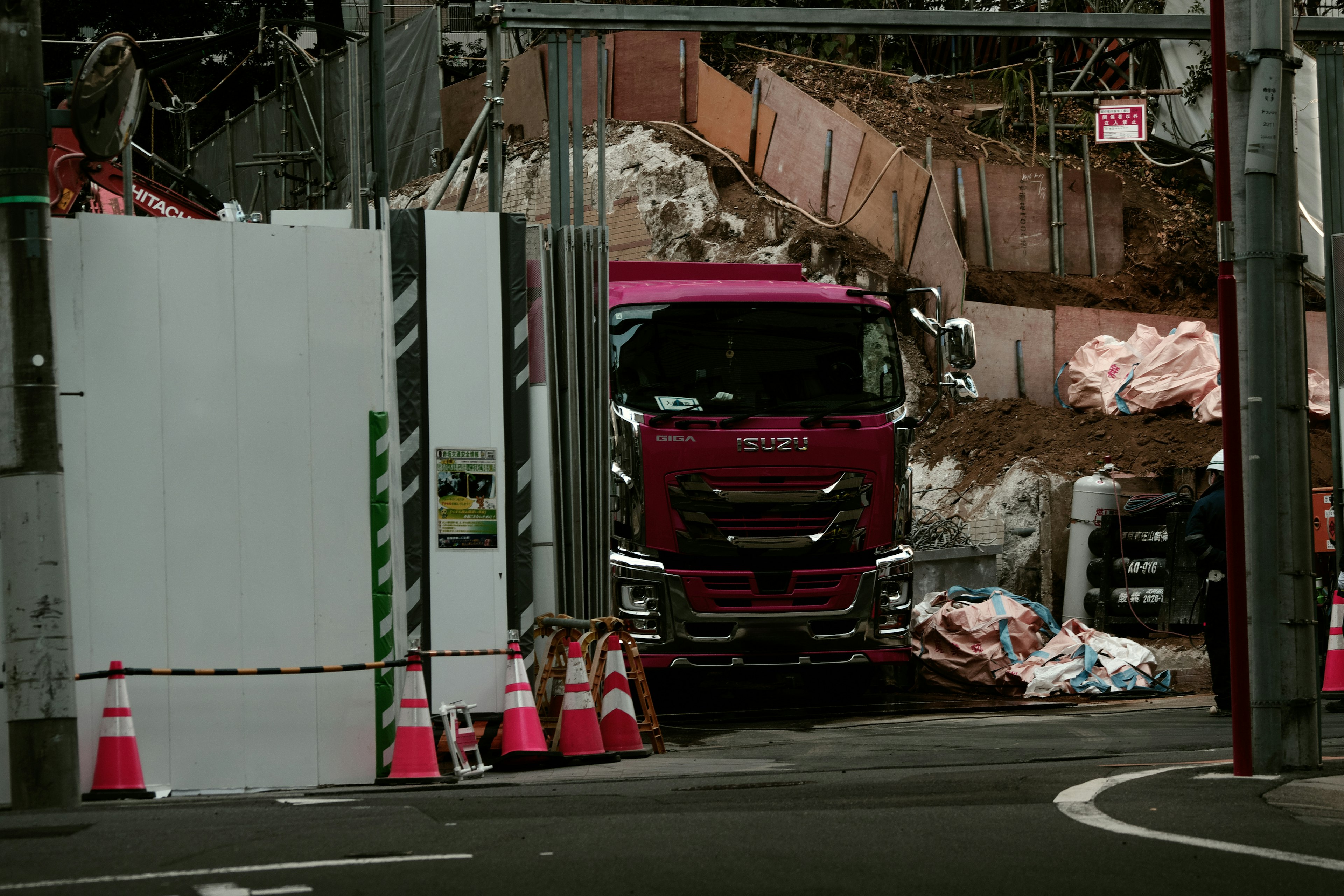 Camion rose garé devant un chantier