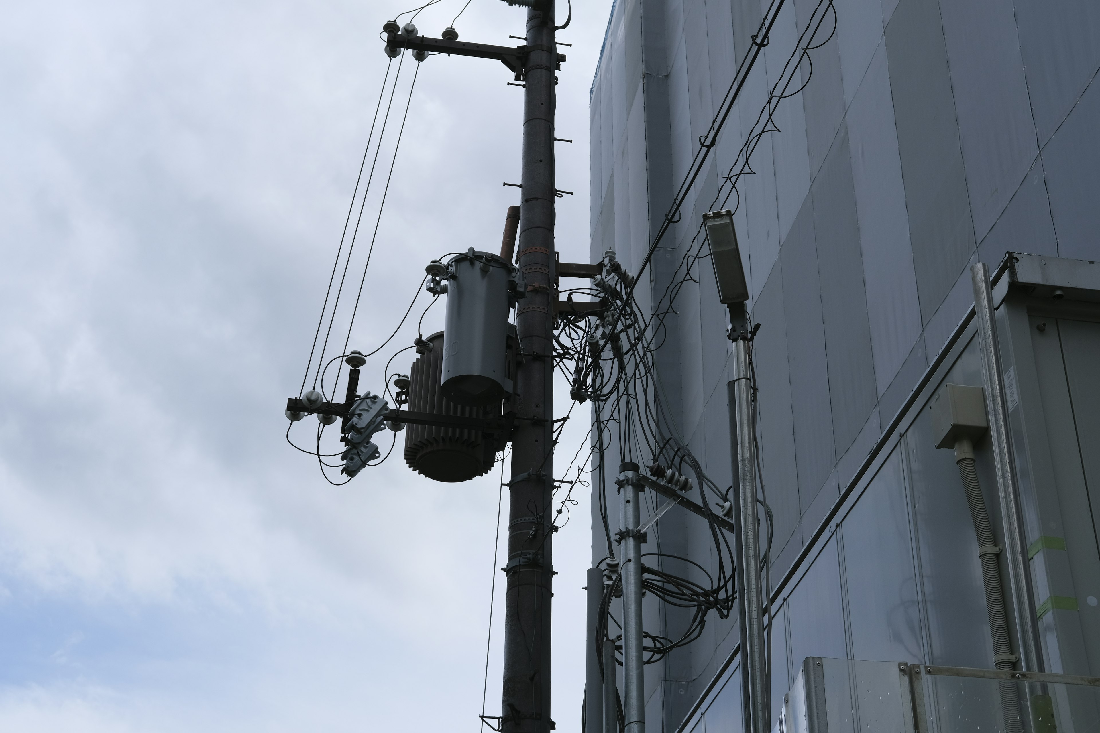 Utility pole with transformer next to a building