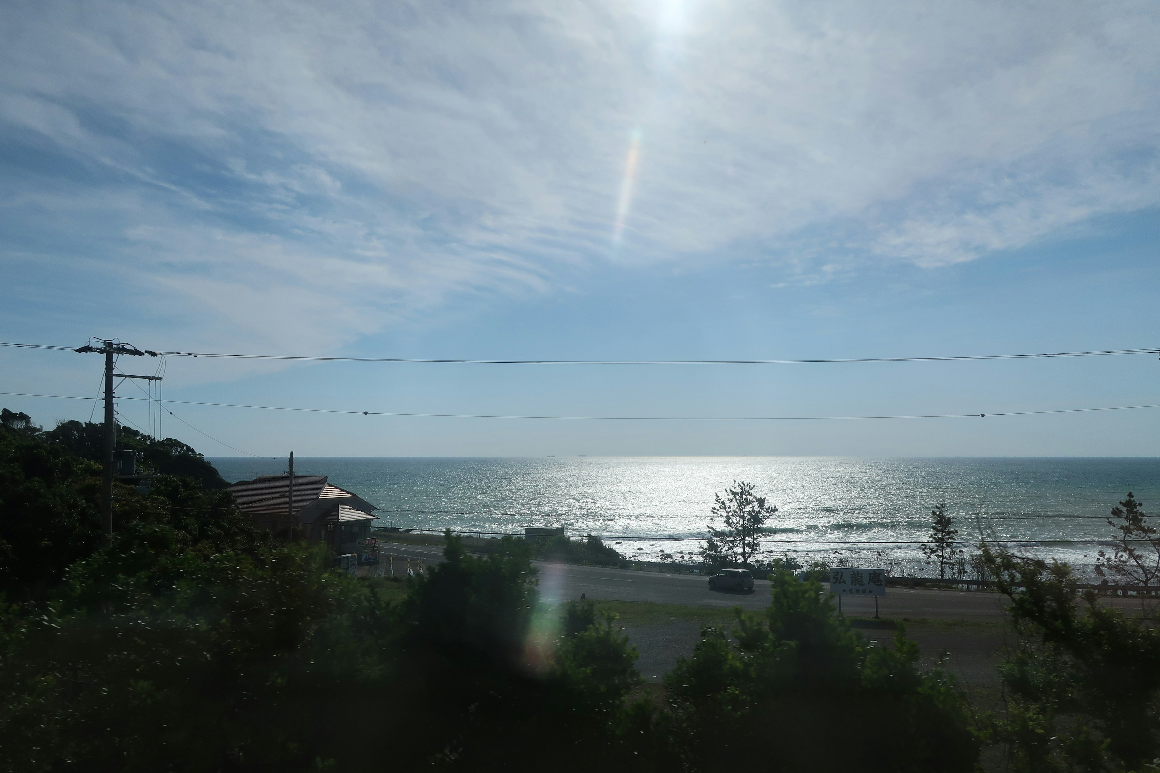 Malersicher Blick auf das blaue Meer und den Himmel mit Sonnenlicht, das auf die Wasseroberfläche reflektiert