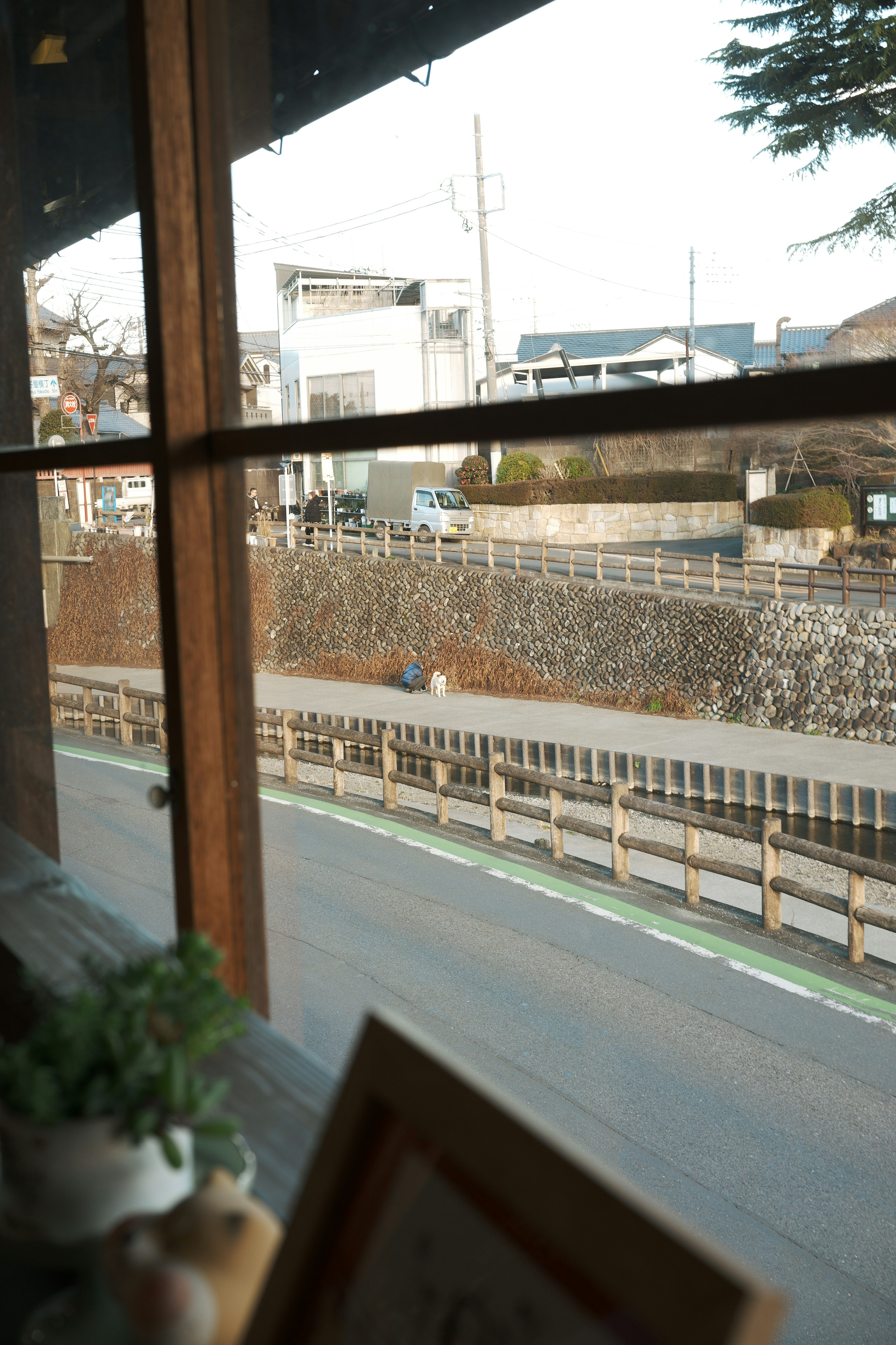 Vue d'une rue calme et d'un mur en pierre depuis une fenêtre