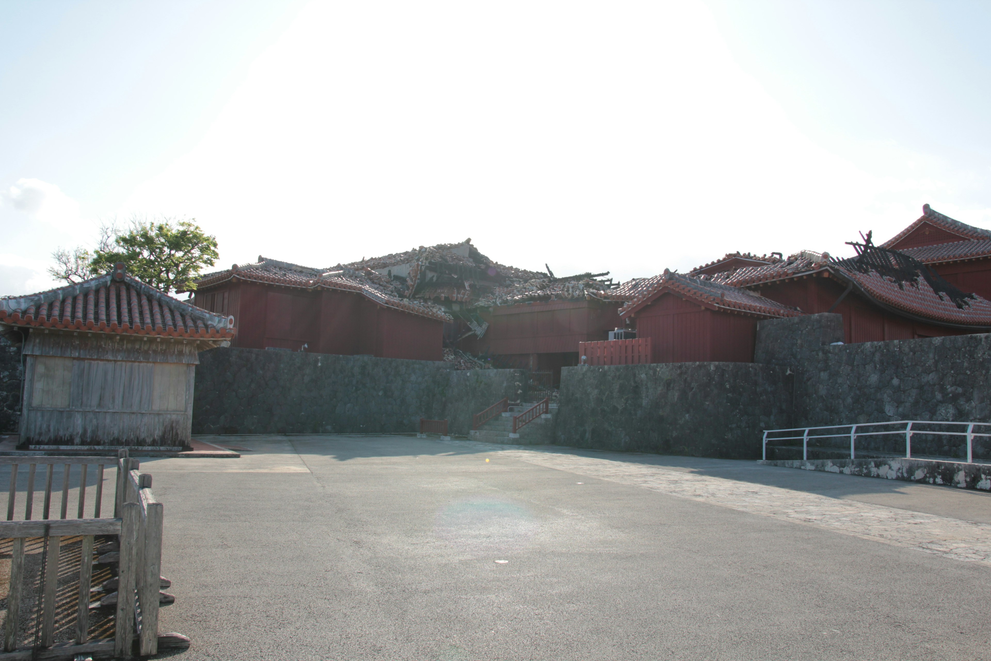 赤い屋根の建物と石壁がある風景