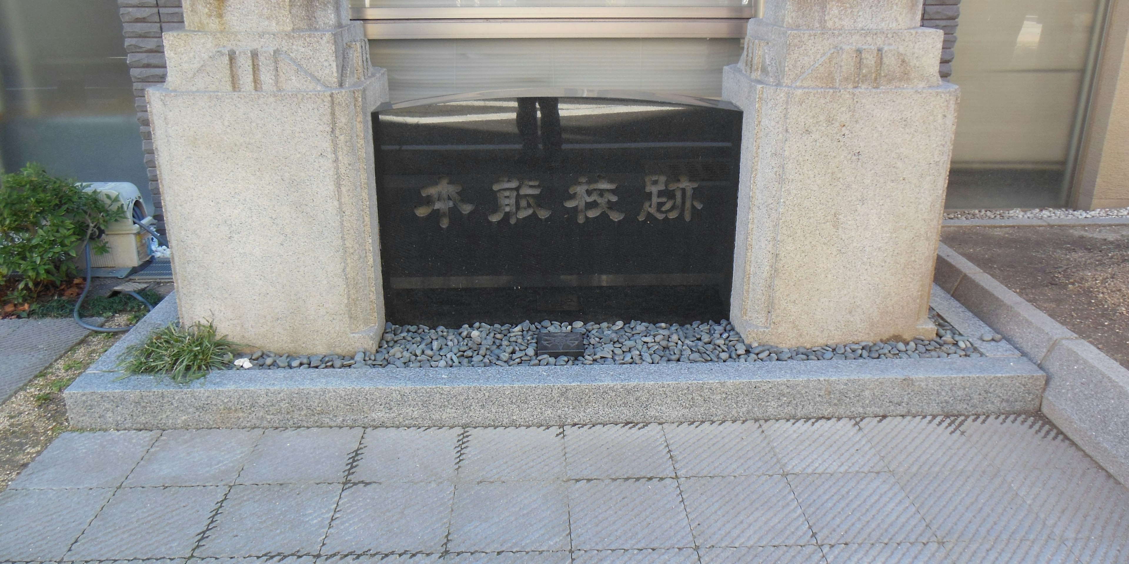 Entrada de un edificio con puerta negra y columnas de piedra