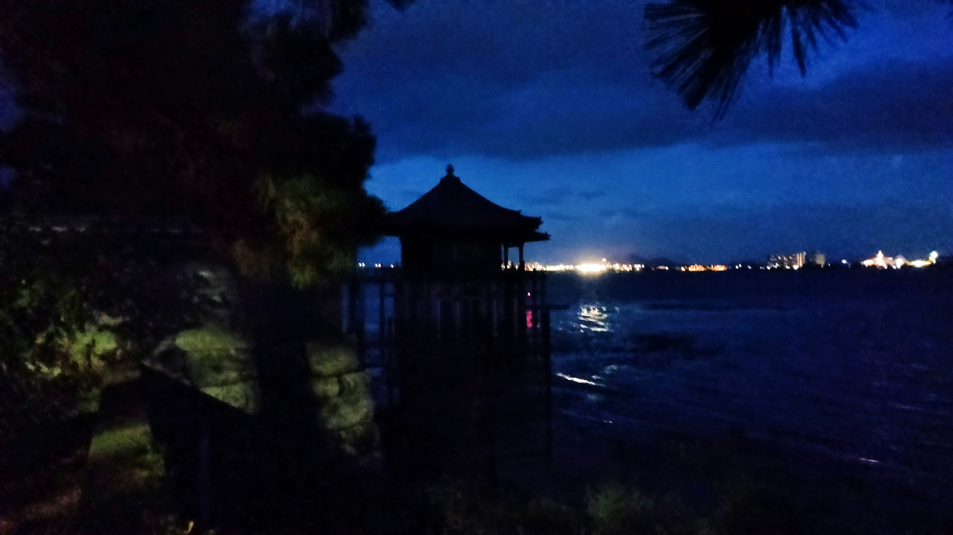 夜の海岸にある小屋と静かな水面の景色