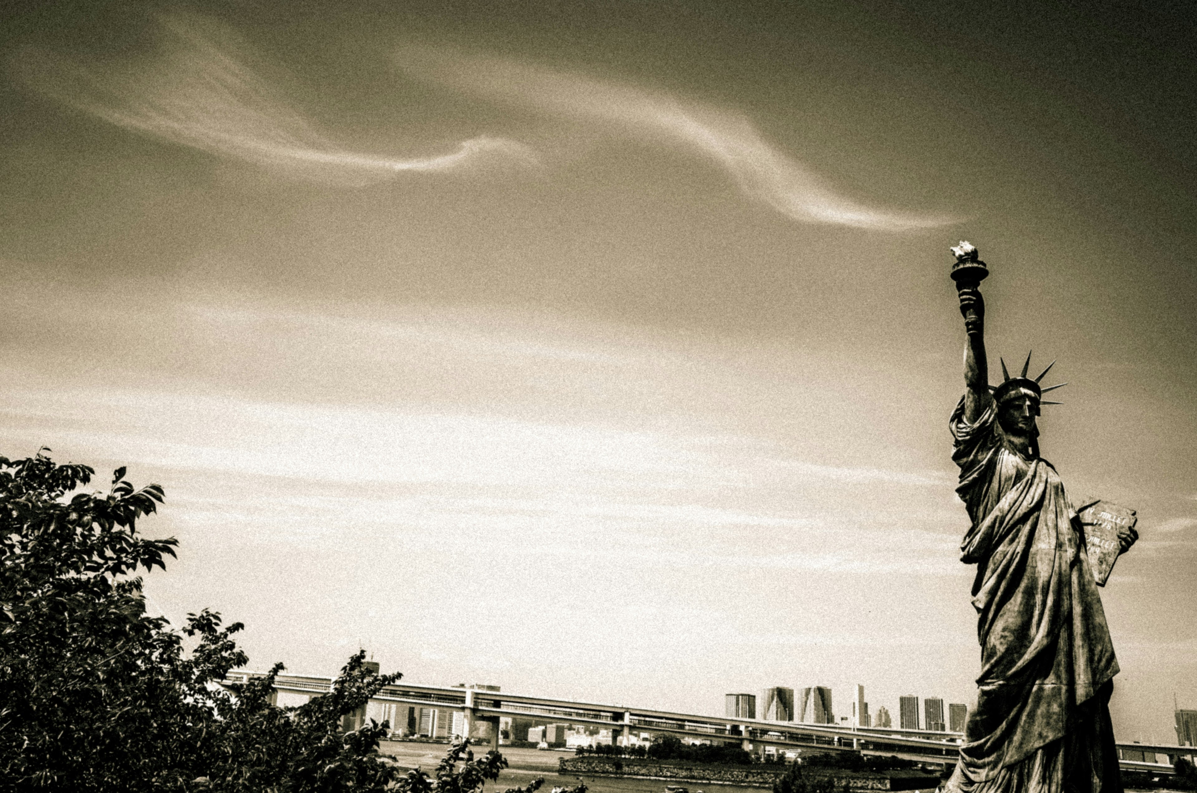 Schwarzweißfoto der Freiheitsstatue mit Wolken im Hintergrund