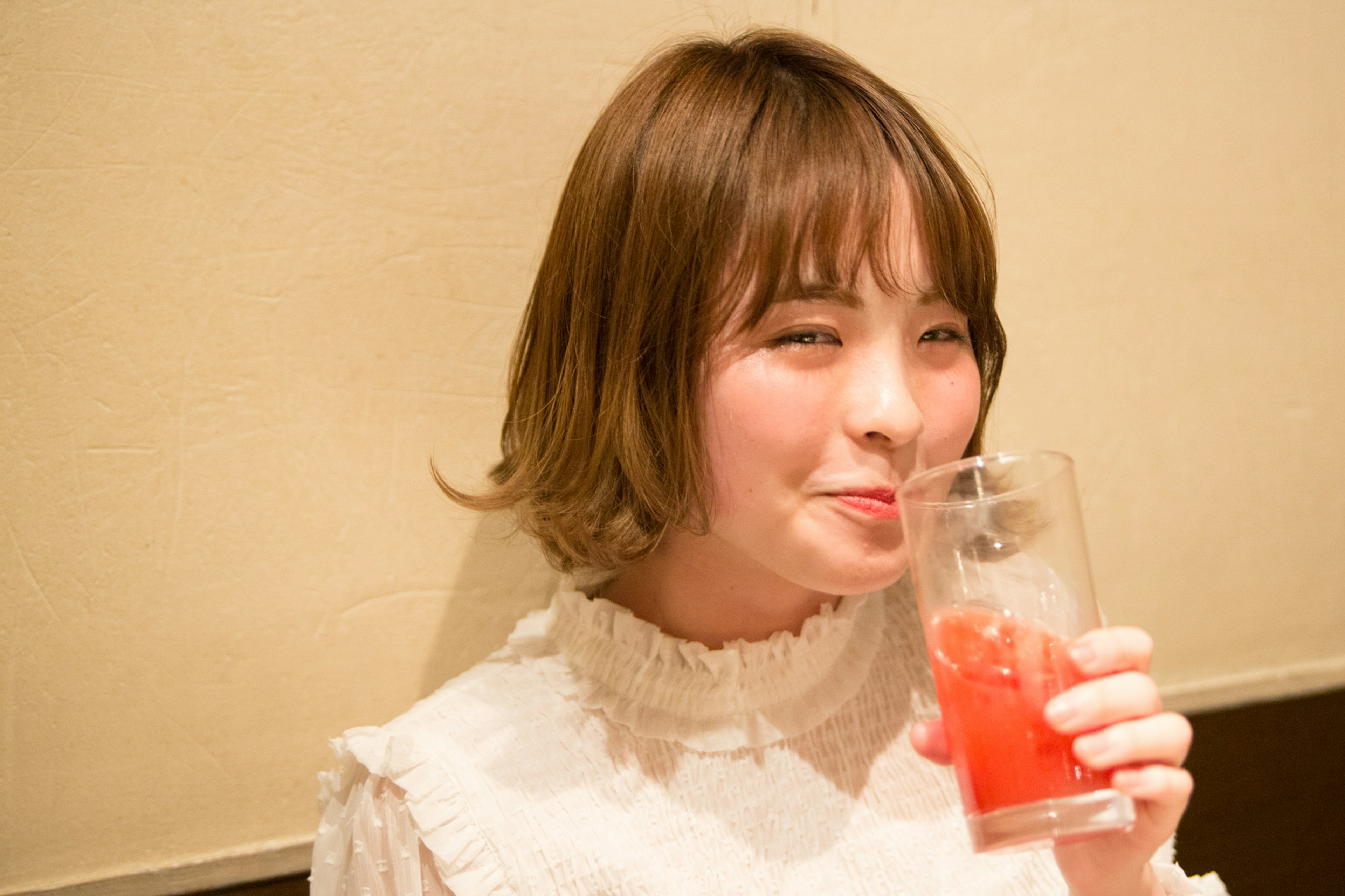 Smiling woman holding a drink Cute hairstyle and white blouse