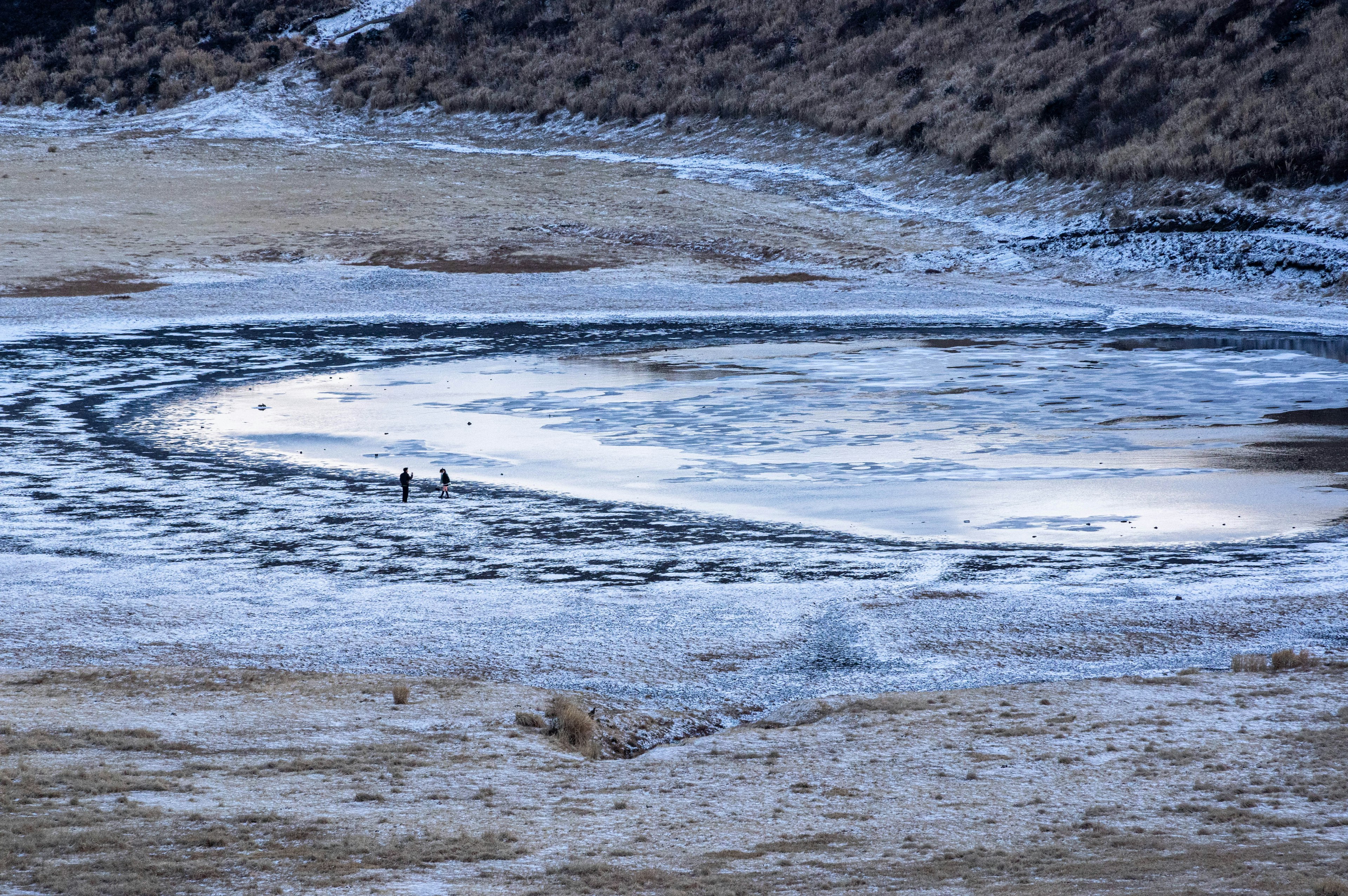 Patterns of snow and ice surrounding a frozen lake