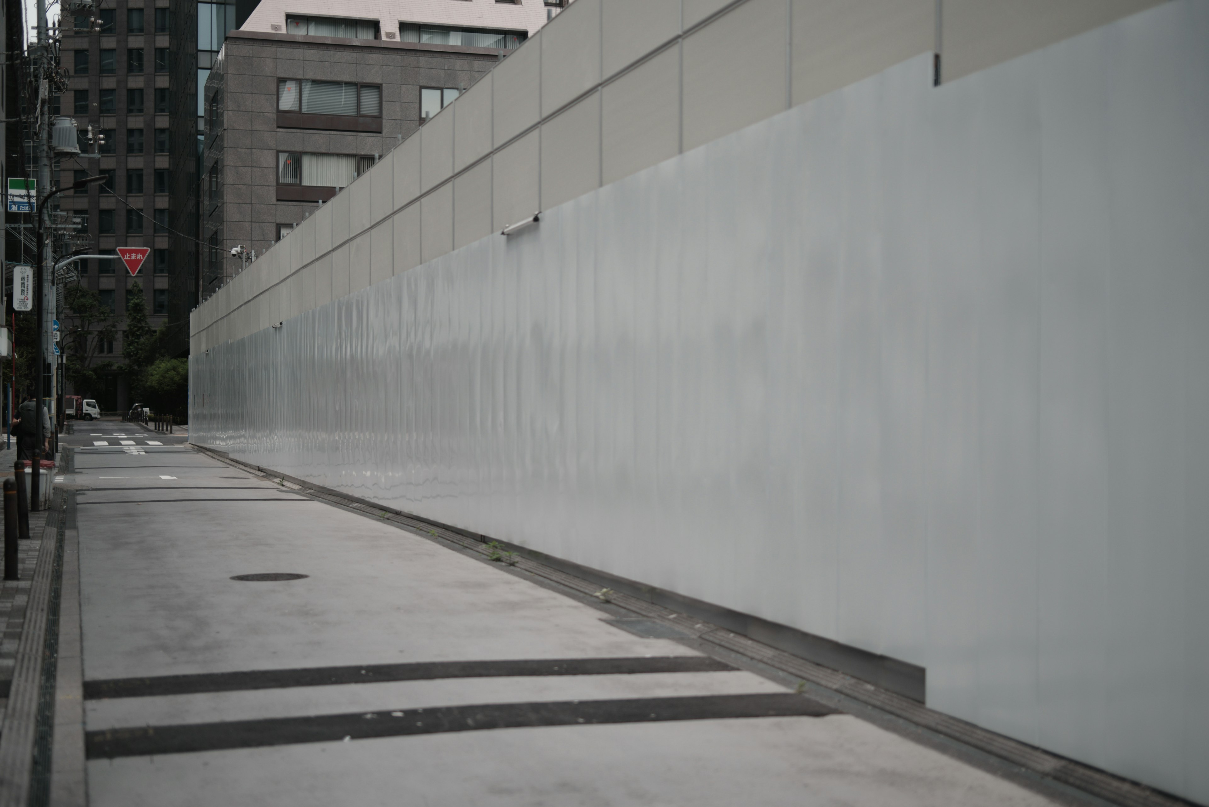 Scène urbaine avec un mur en béton et une route pavée