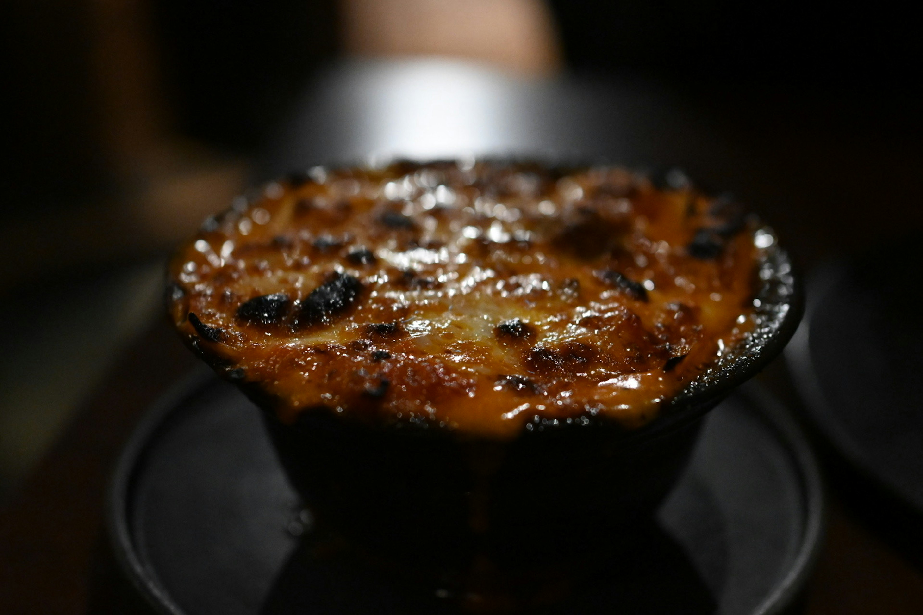 Plat avec un dessus de fromage doré et une sauce crémeuse