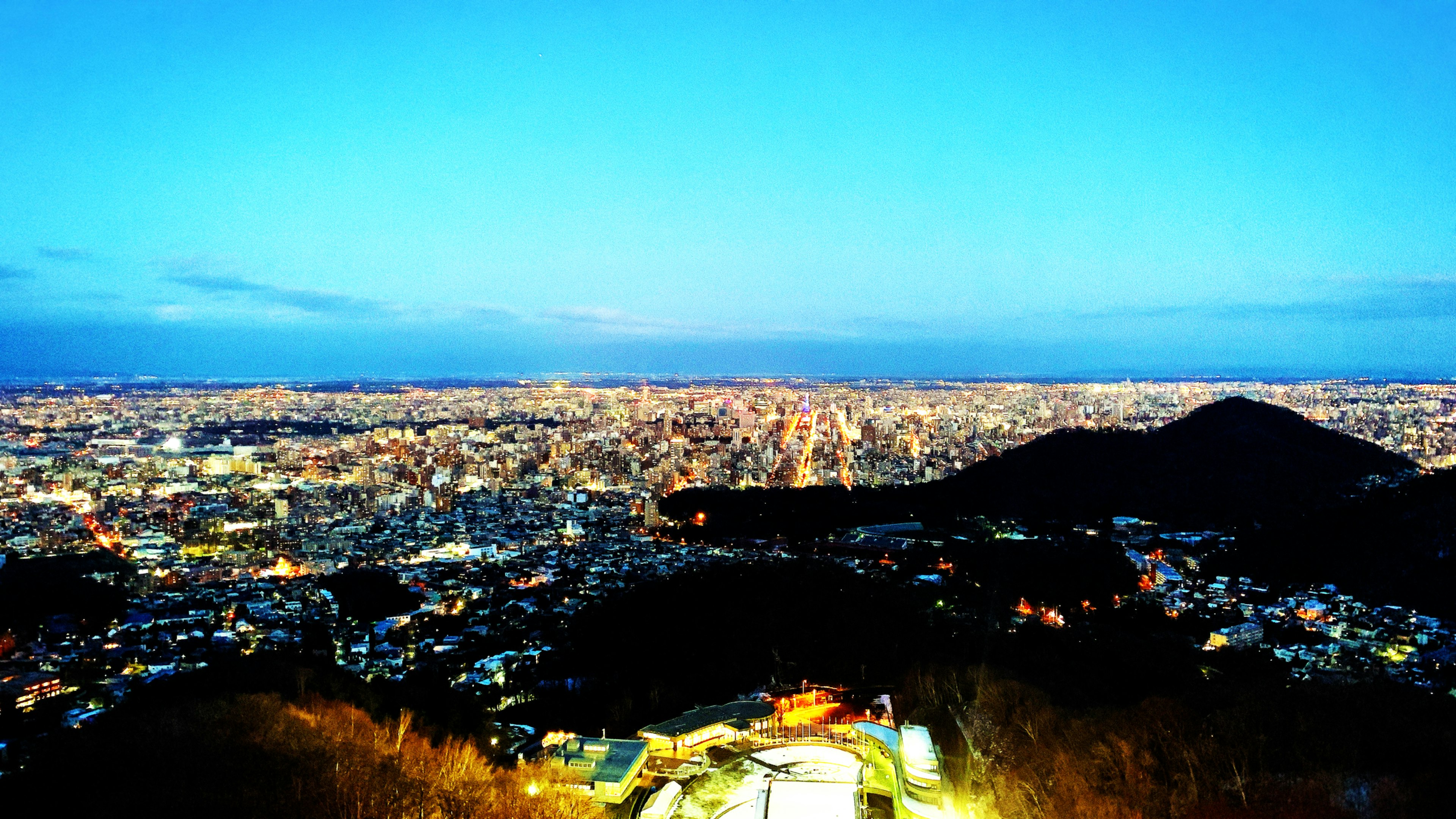 Stupenda vista notturna di un paesaggio urbano con montagne sullo sfondo