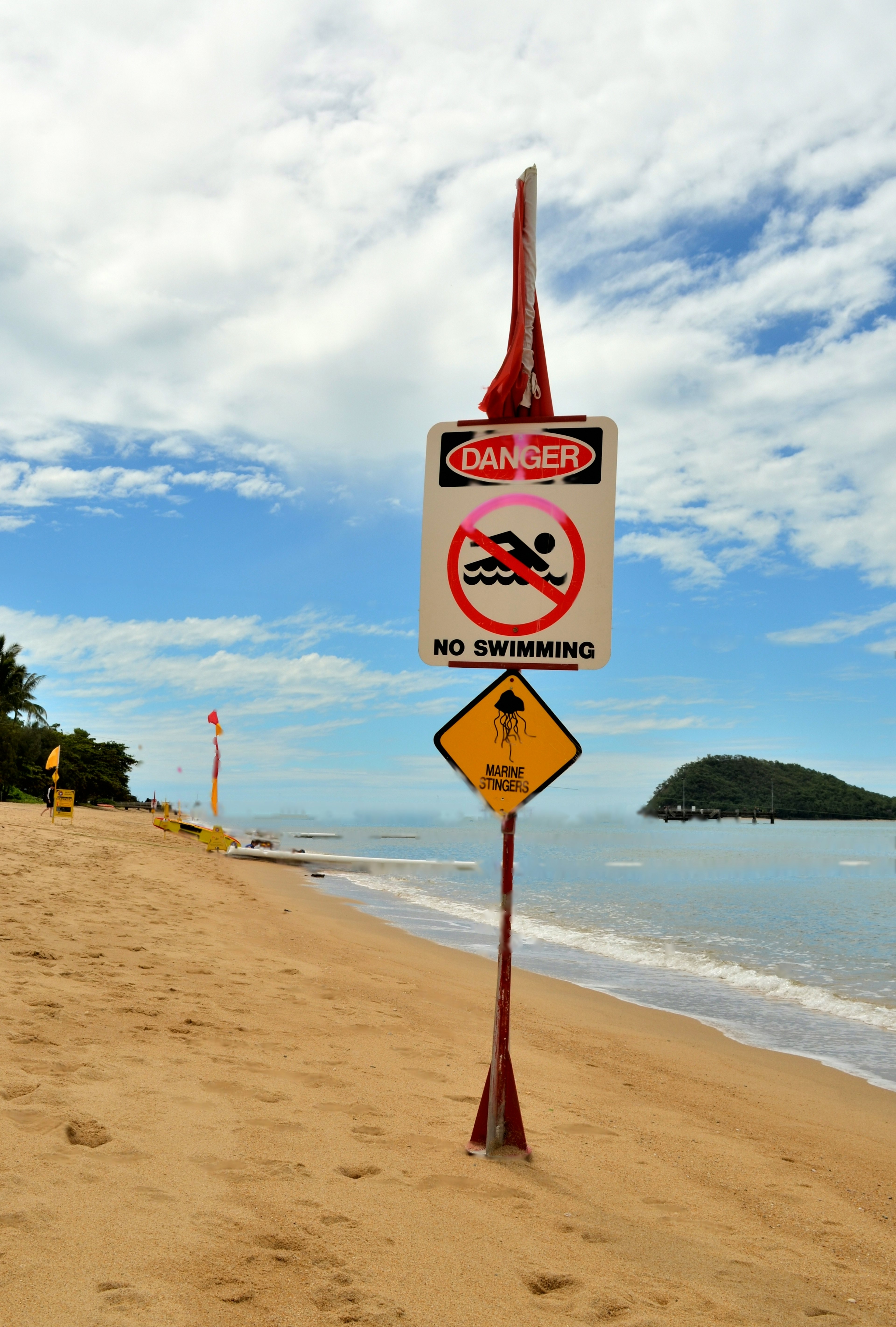 Escena de playa con señales de advertencia contra nadar