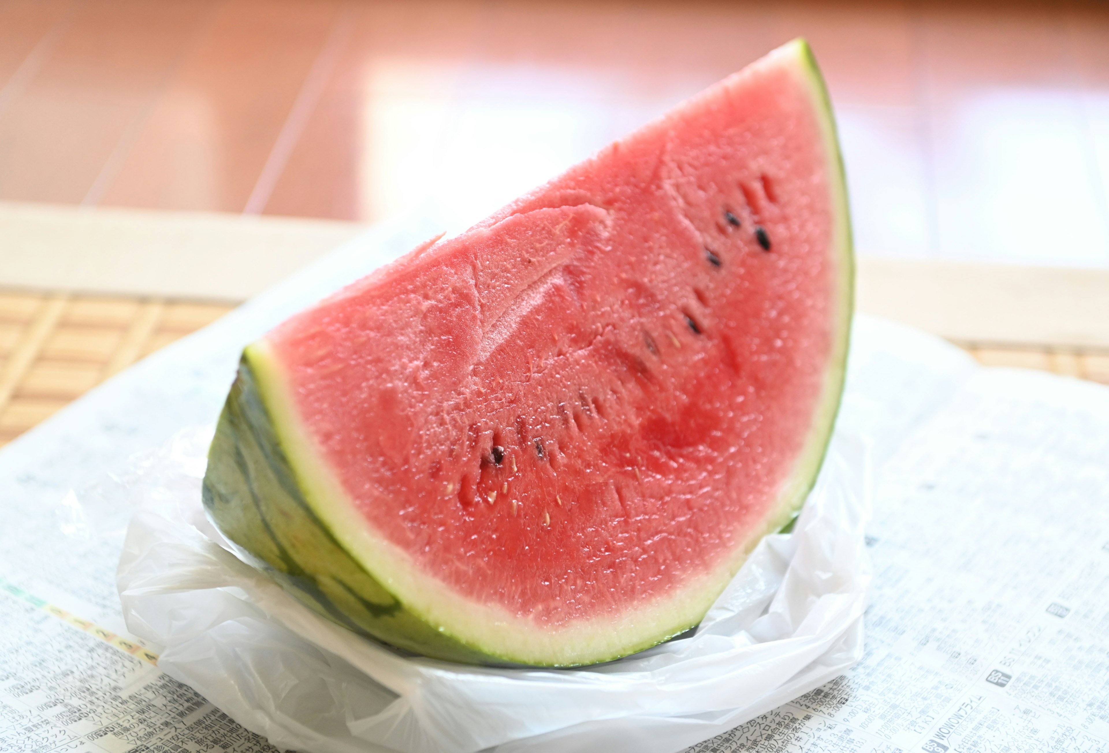 A slice of watermelon placed on a white plate