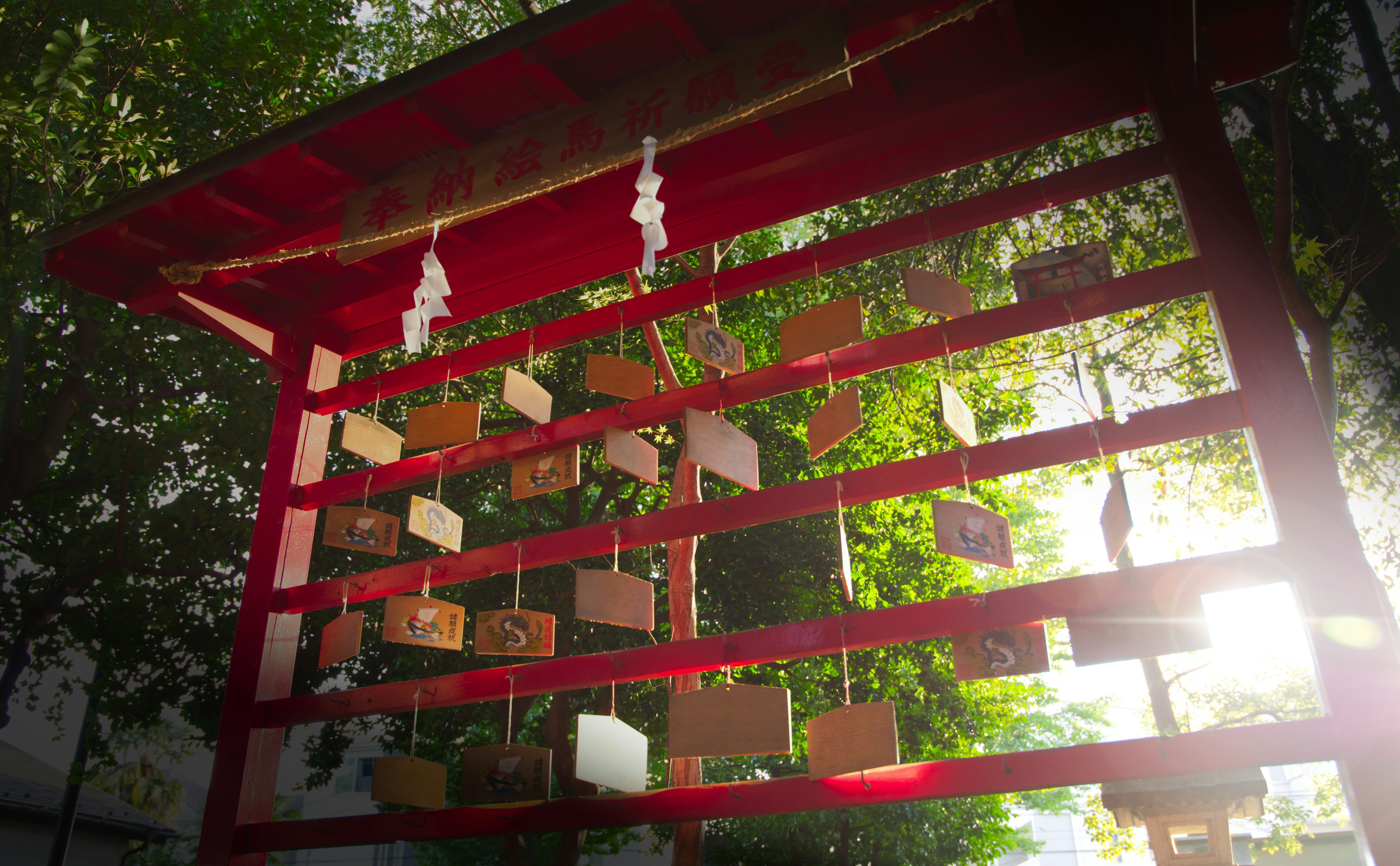 A red shrine with wooden ema plaques hanging