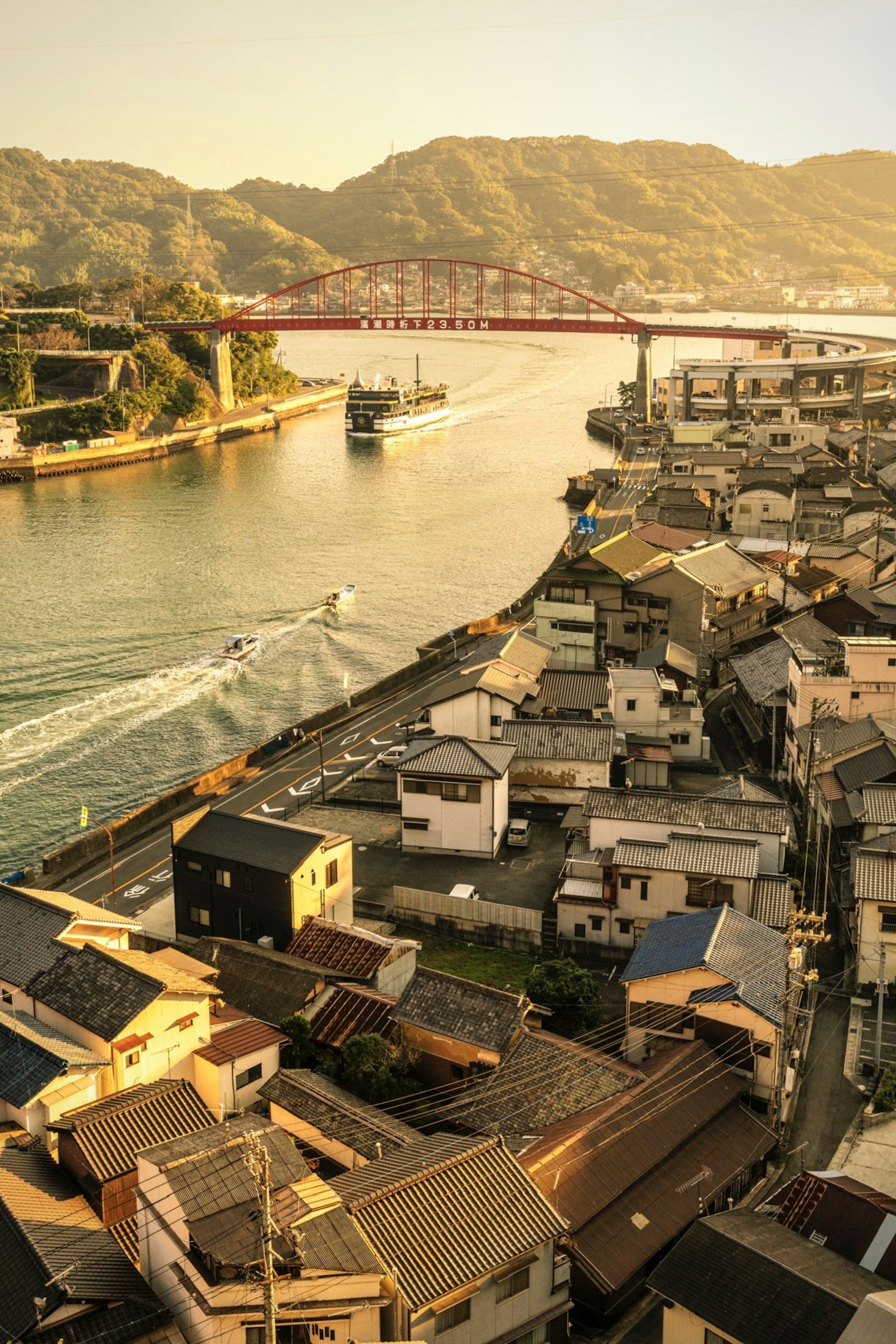 夕暮れ時の川沿いの家々と橋の風景