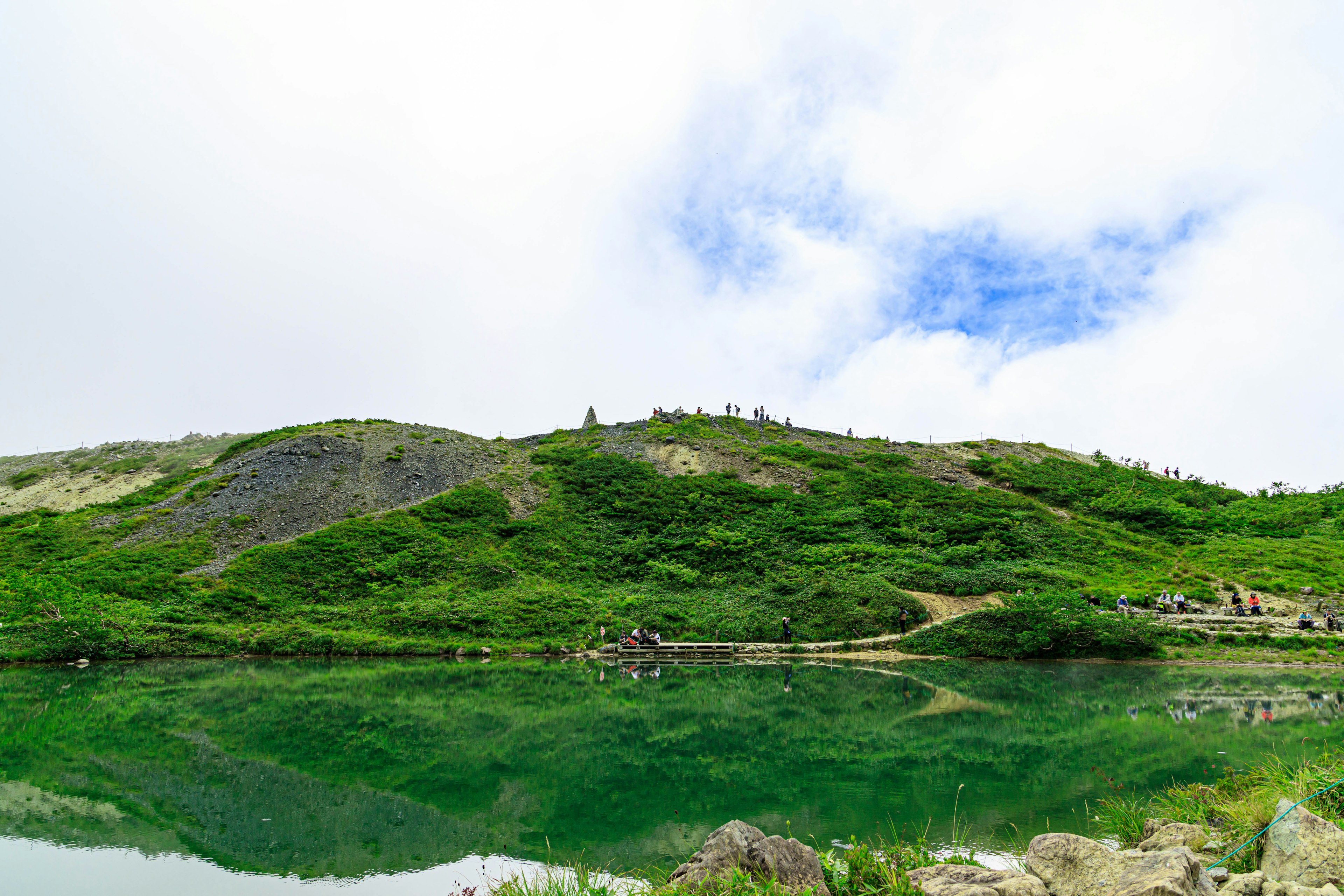 Pemandangan perbukitan hijau dan danau tenang