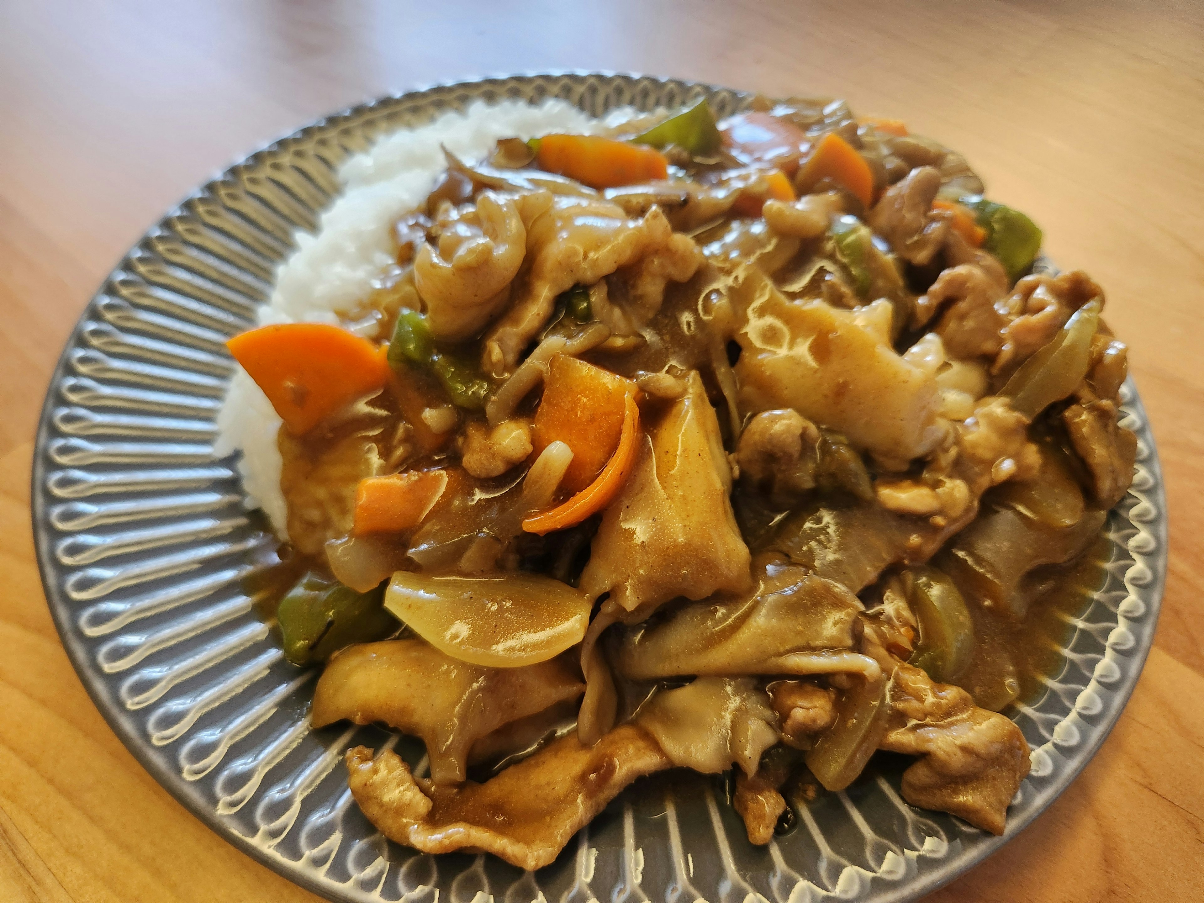 Plato de cocina china con verduras y carne sobre arroz blanco