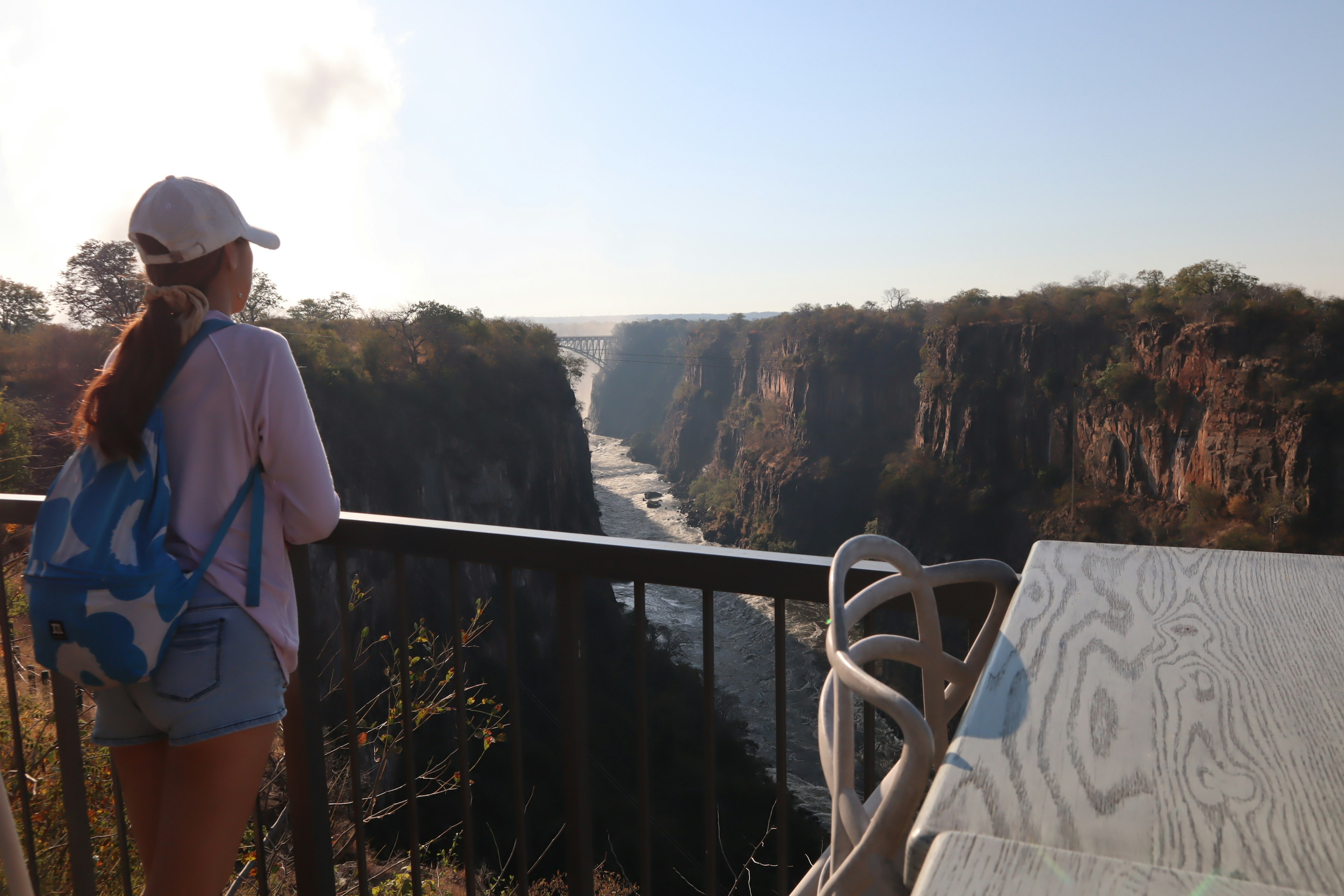 Frau, die auf eine weite Schlucht und Flusslandschaft blickt